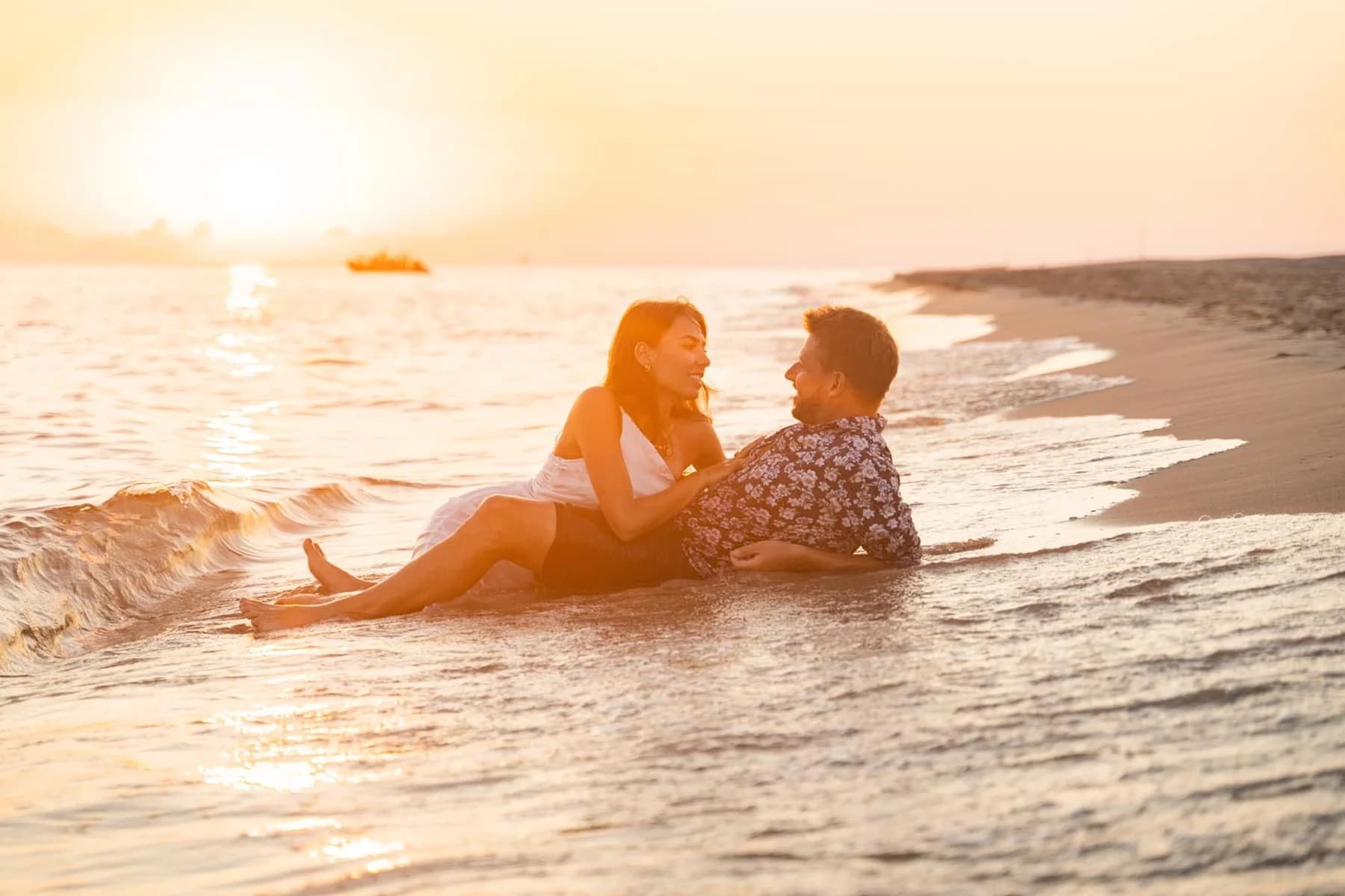 Séance couple dans les vagues au coucher du soleil