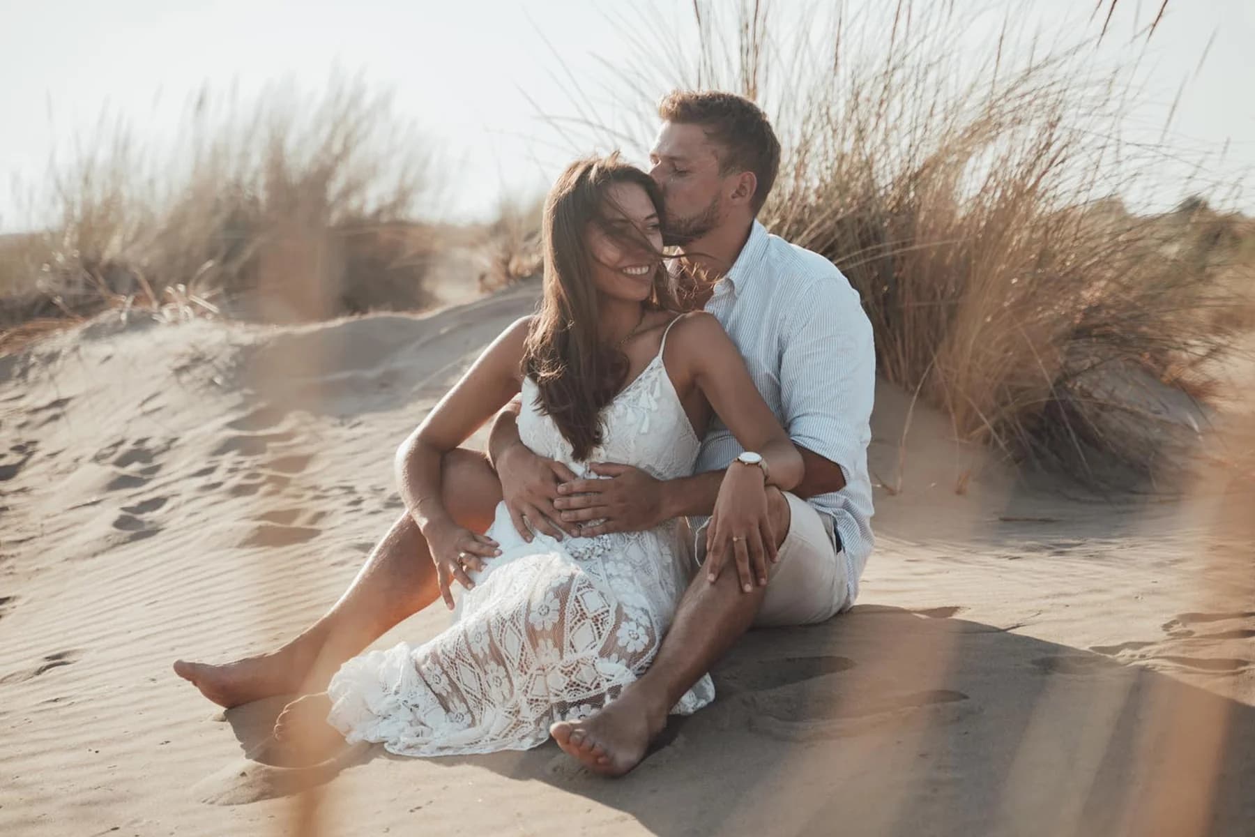 Séance photo couple dans les dunes - baiser et complicité