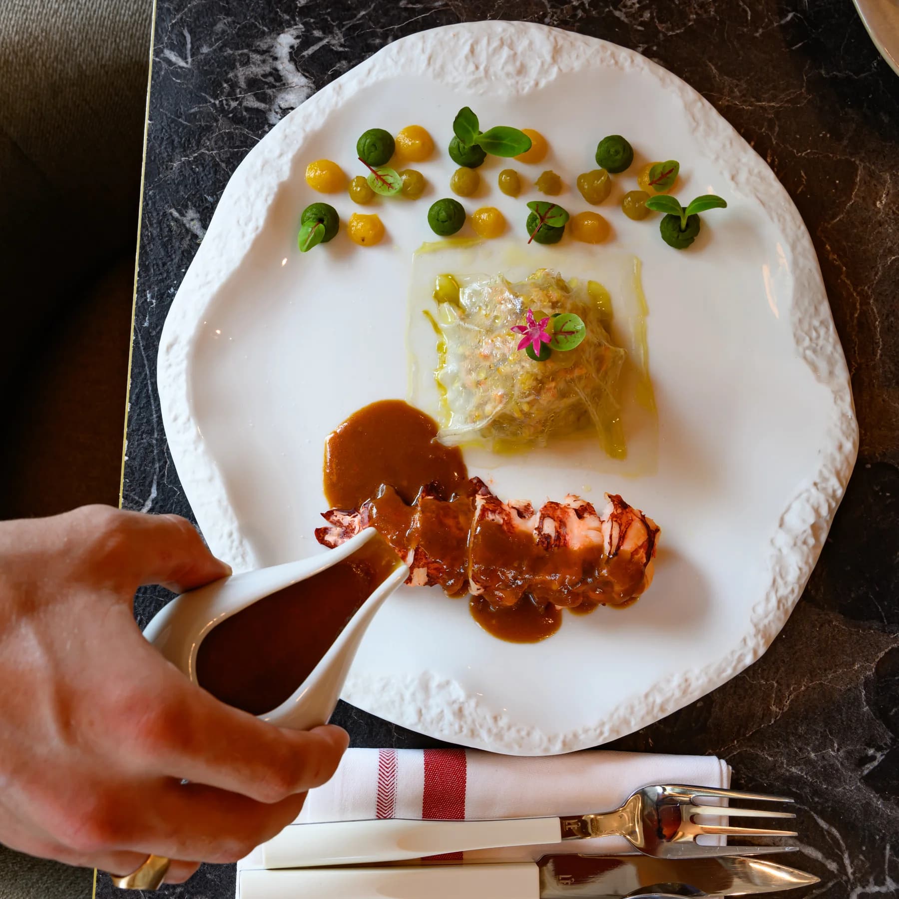 Photo culinaire dressage sauce sur langoustine par le chef