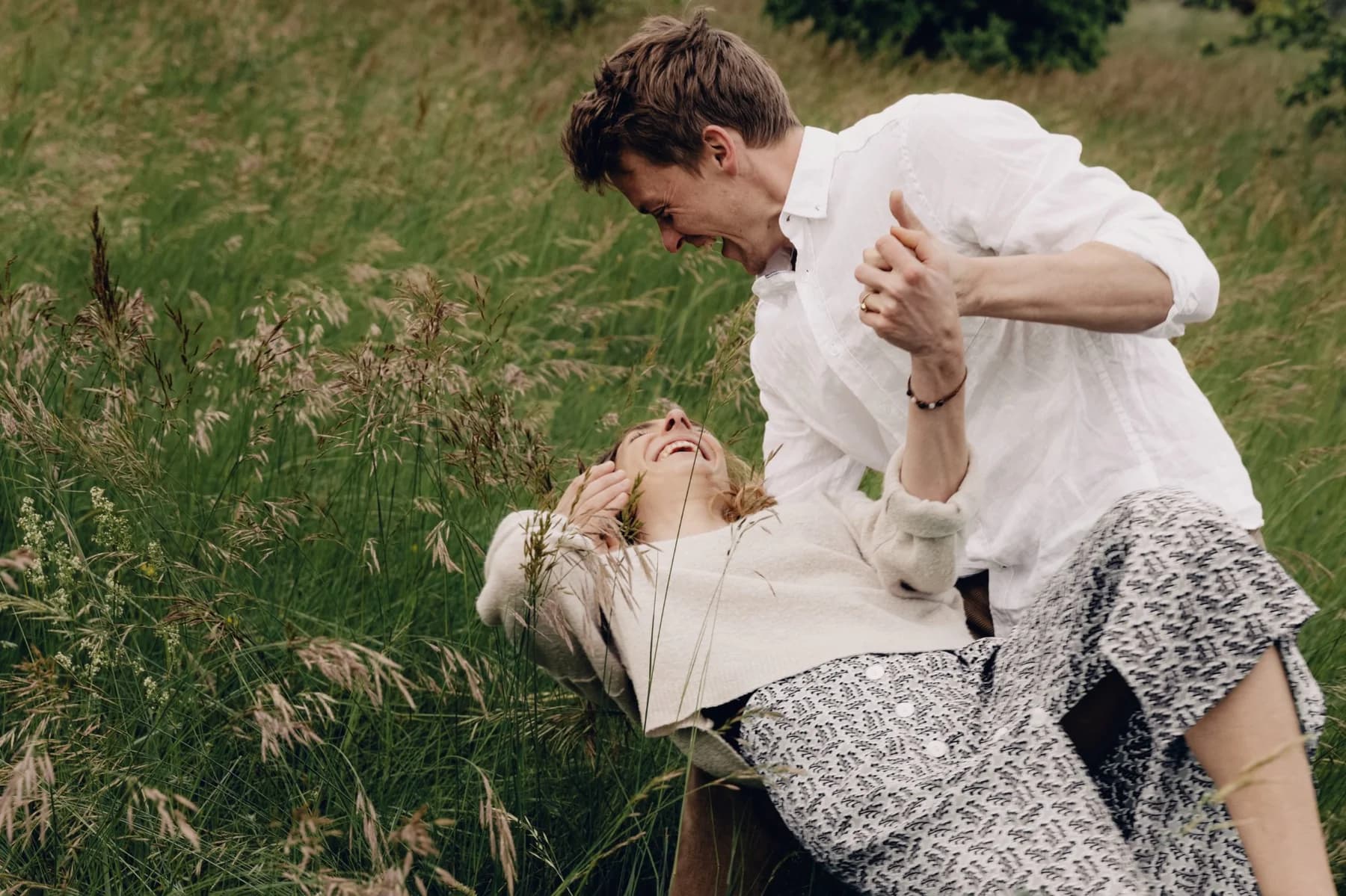 Photo famille couple riant dans les herbes hautes - moment spontané