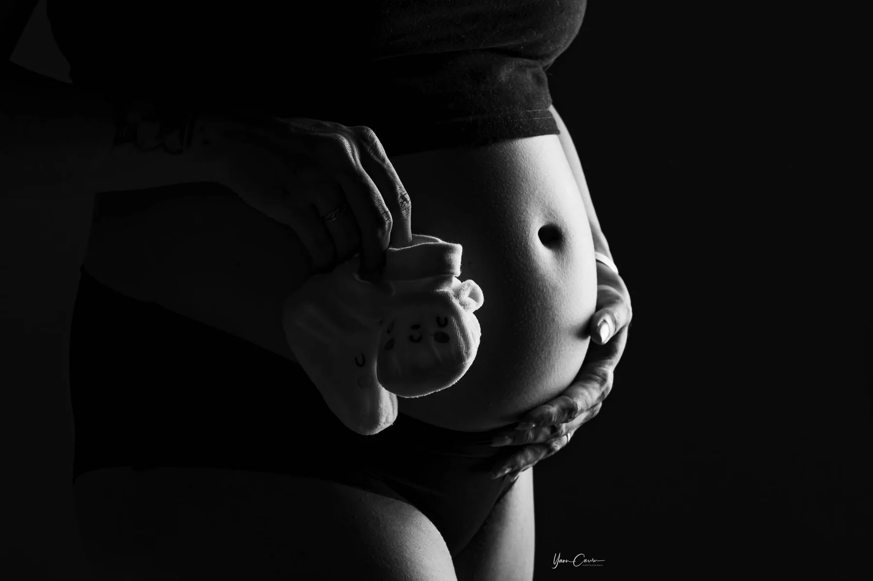 Détail grossesse ventre chaussons bébé noir et blanc