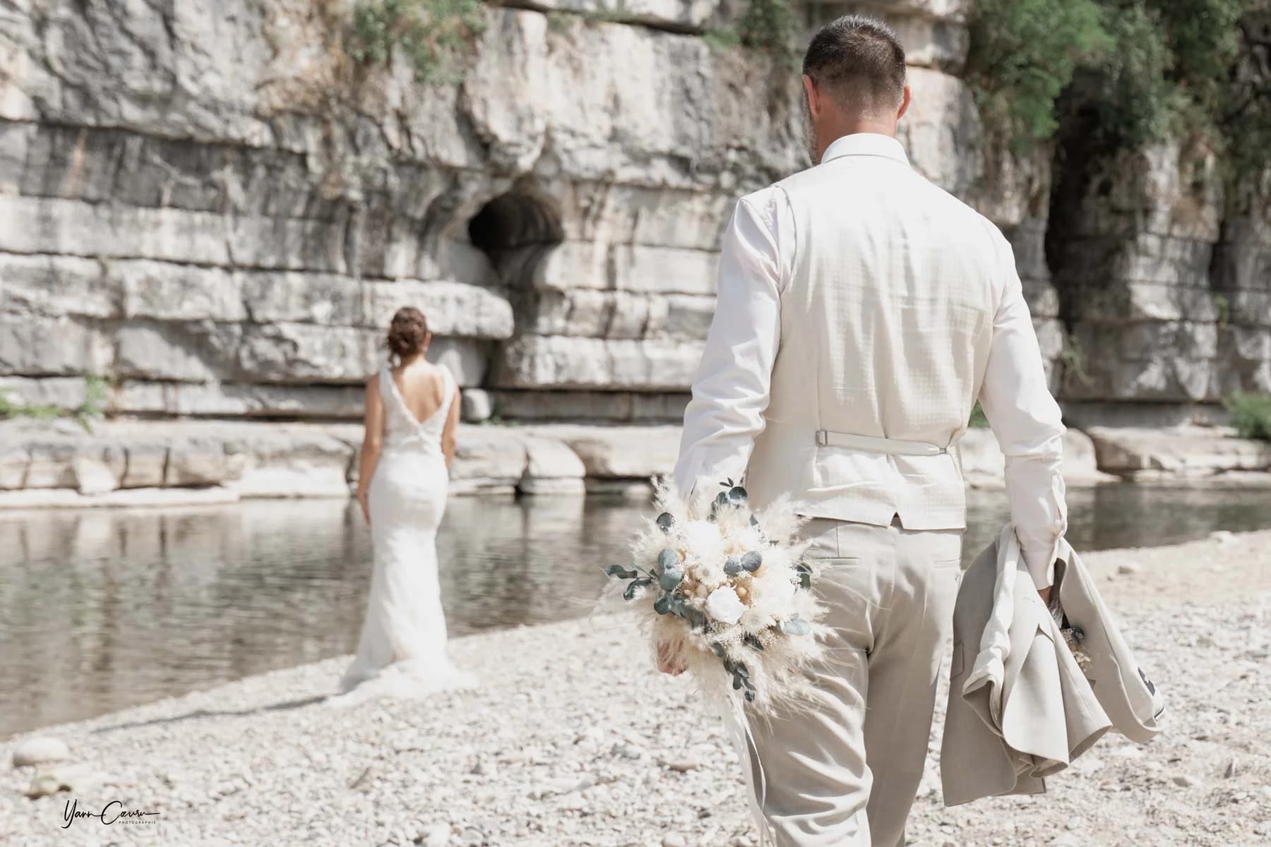 Couple de mariés au bord de la rivière avec falaises en Ardèche