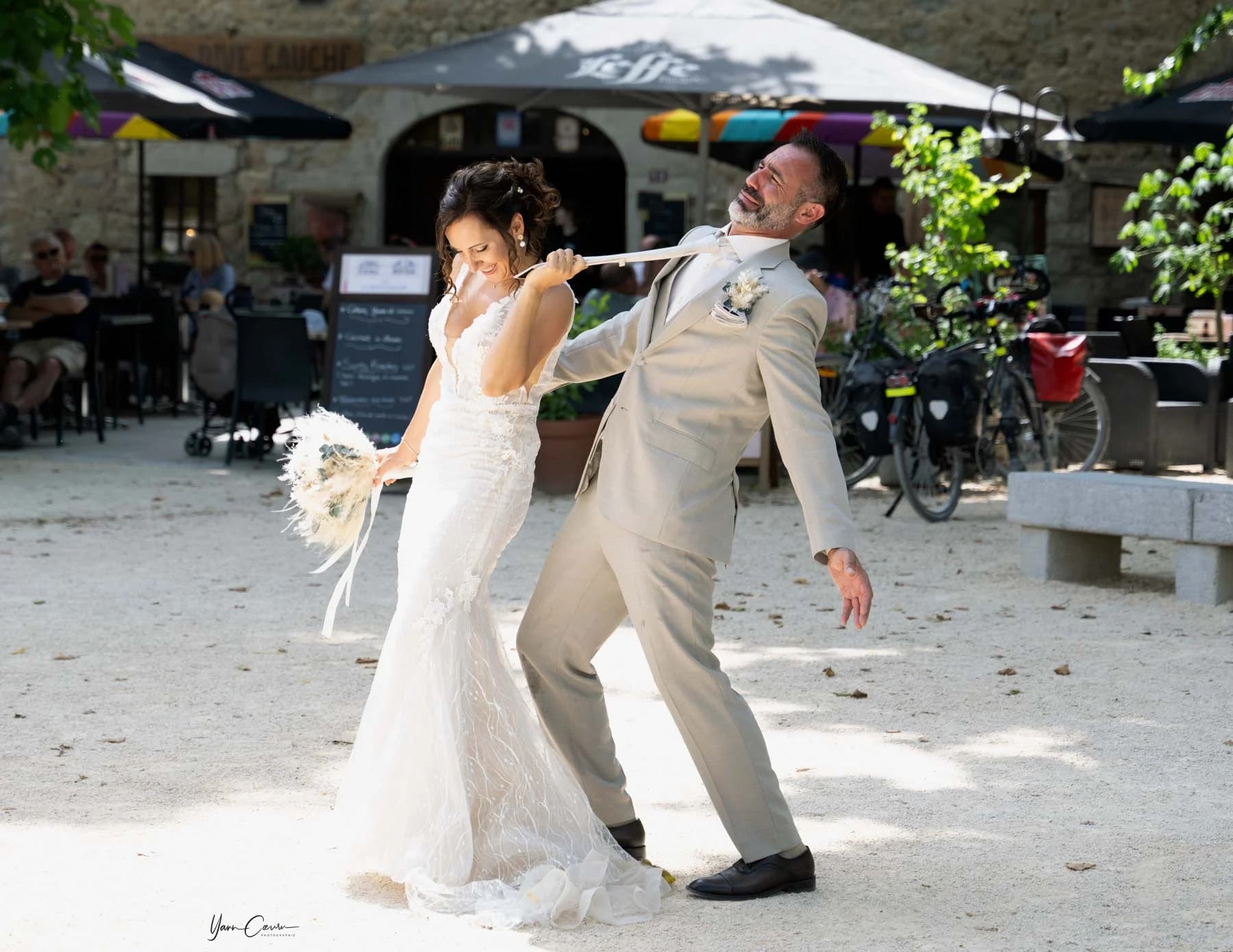 Mariée tirant la cravate du marié dans un village en Ardèche