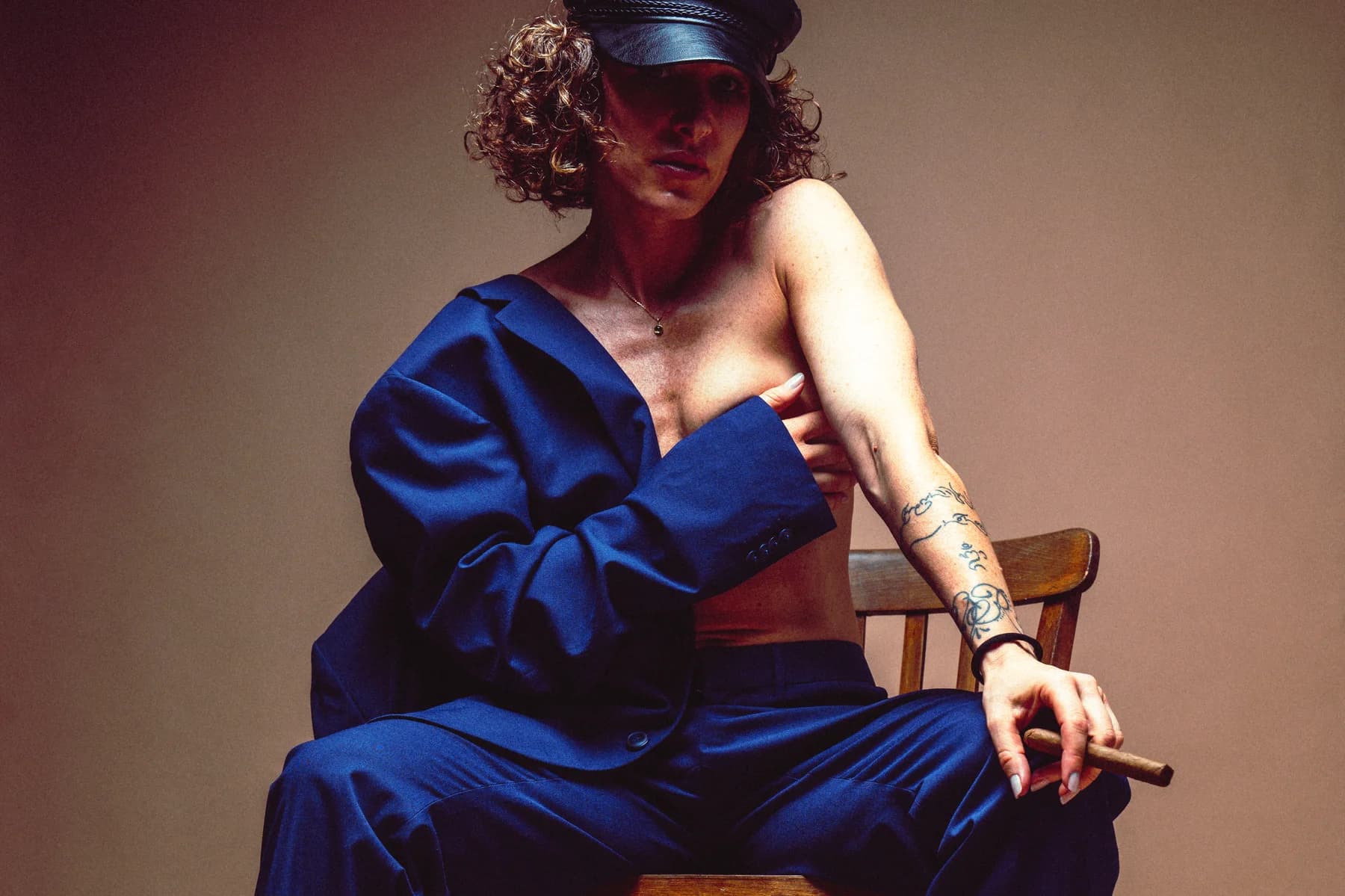 Shooting mode éditorial costume bleu et casquette en studio