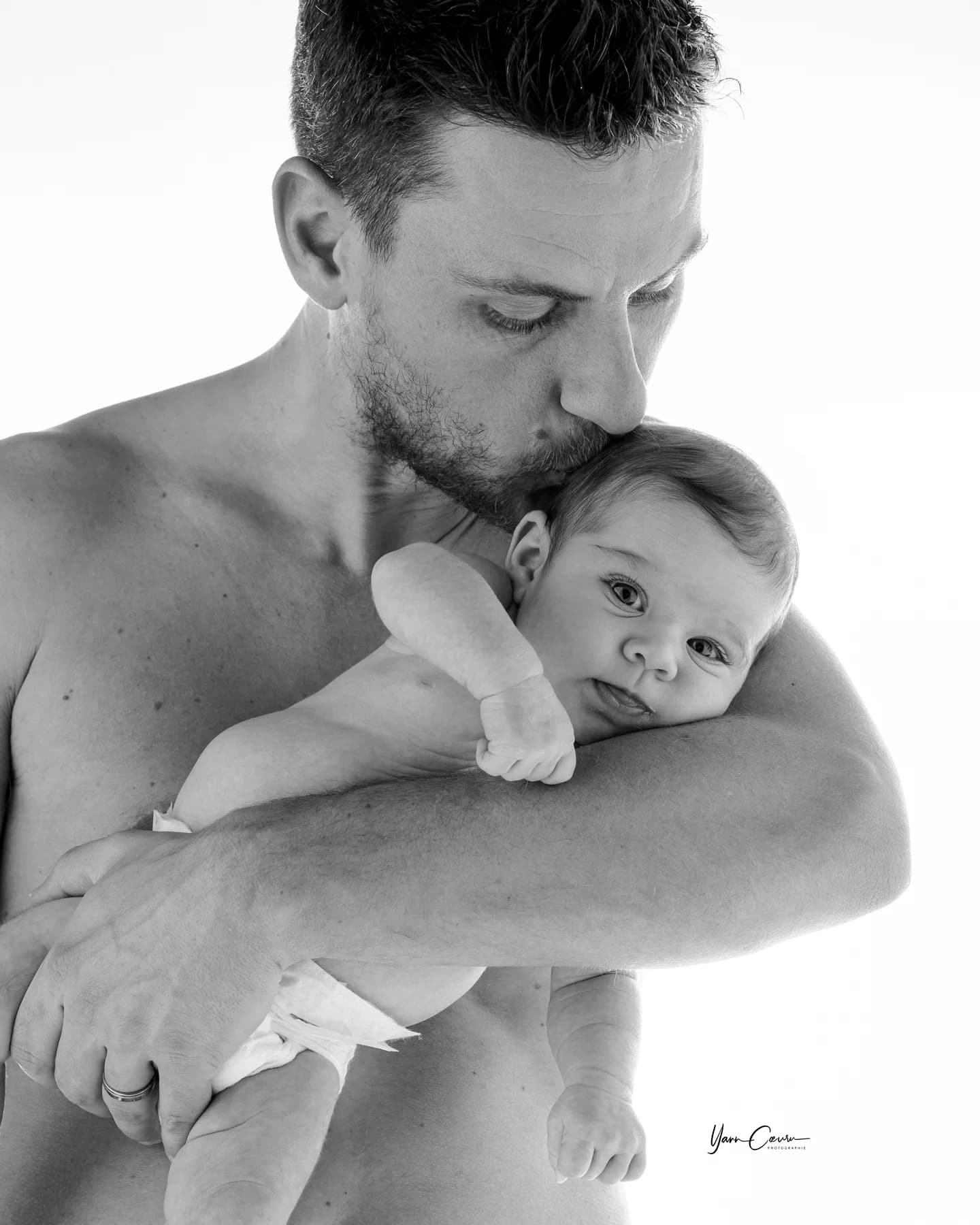 Papa faisant un câlin à son nouveau-né en noir et blanc