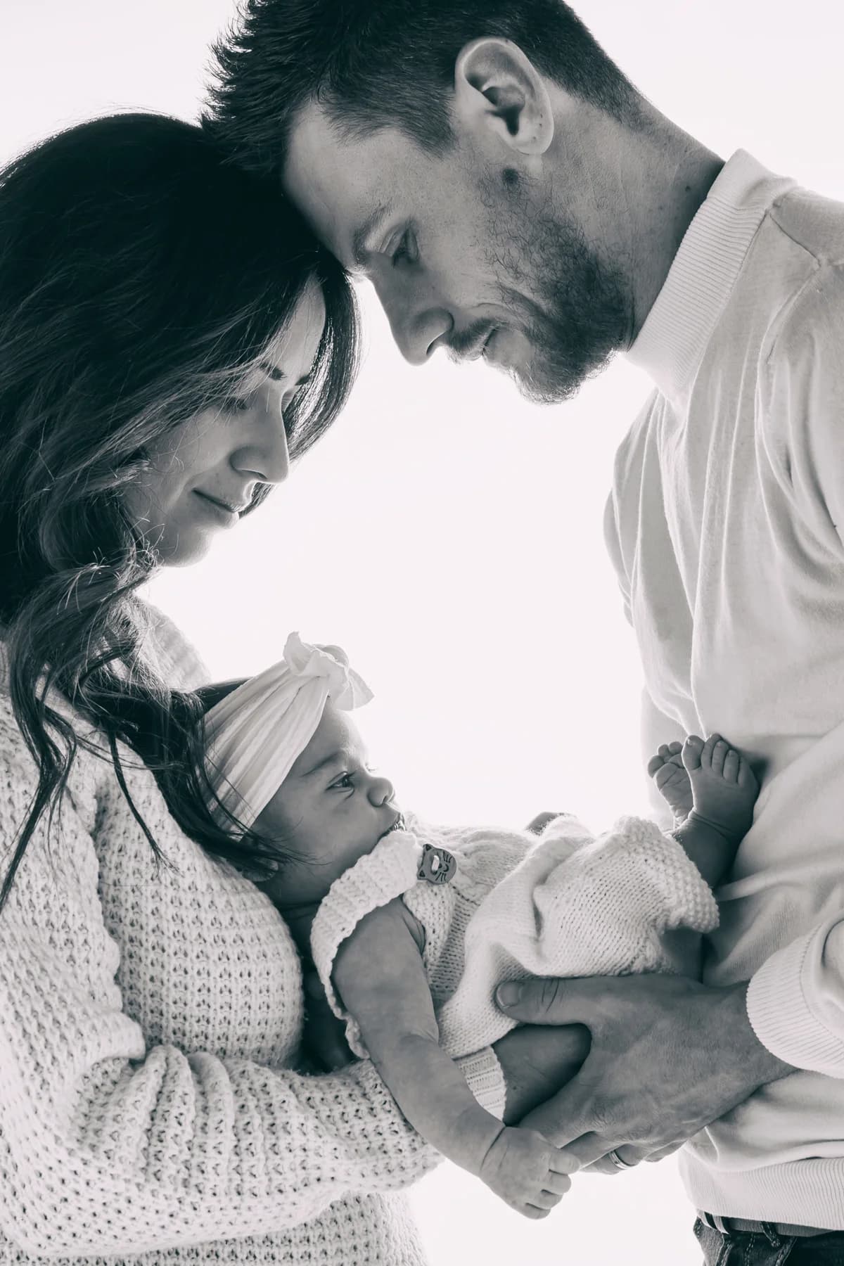 Papa tenant son nouveau-né dans les bras en noir et blanc