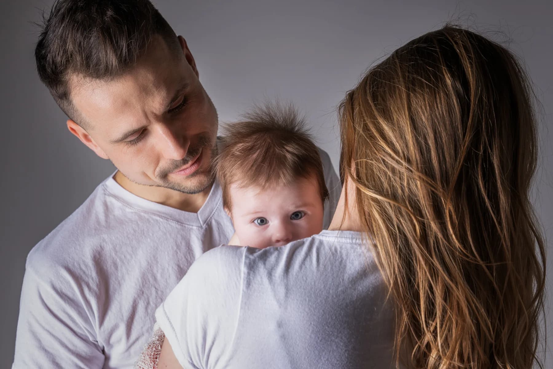 Parents avec bébé regardant la caméra en studio