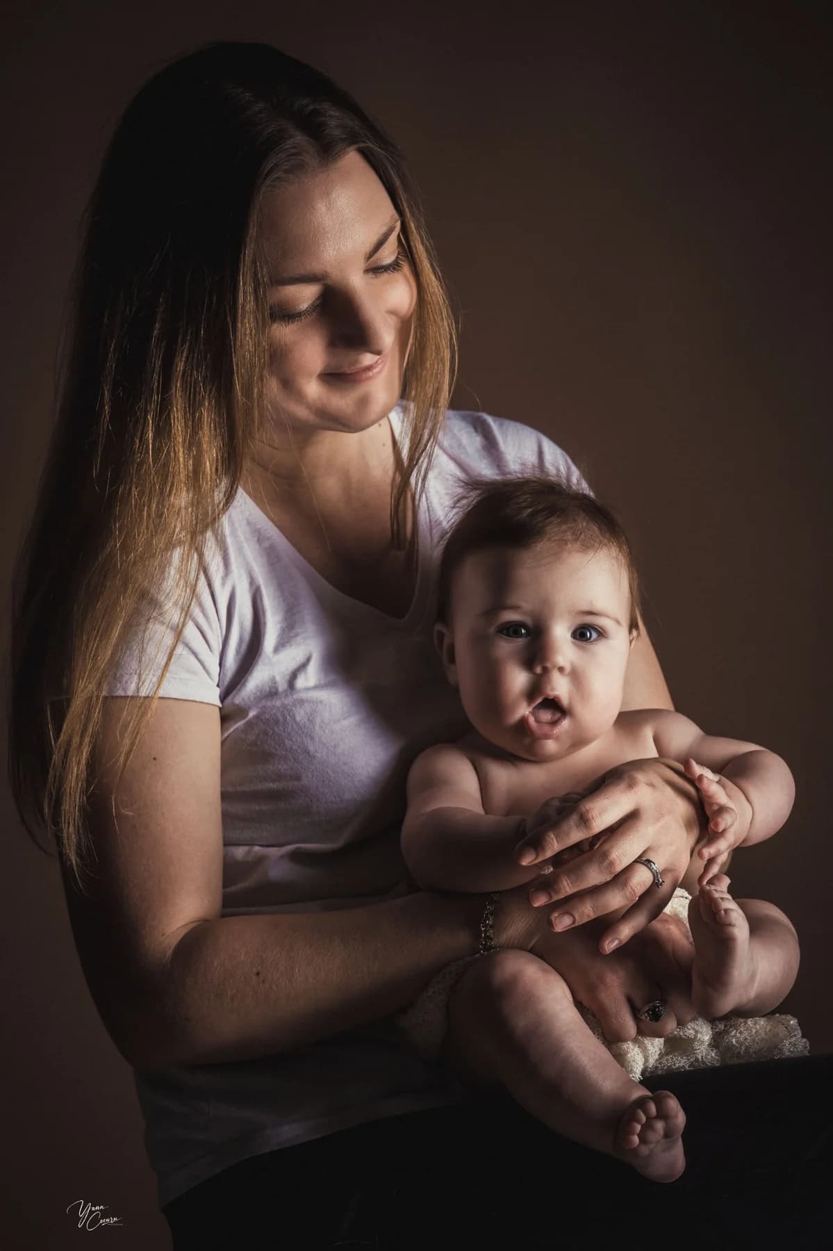Maman tenant son bébé avec tendresse en studio photo