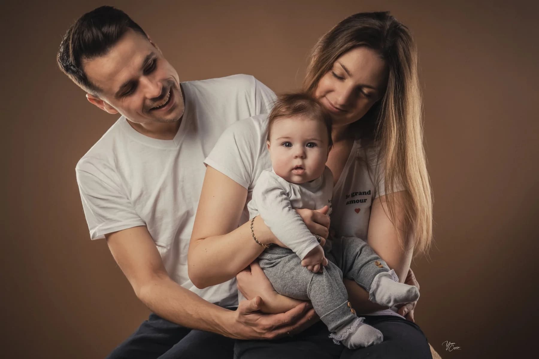 Parents souriants avec leur bébé lors d'une séance naissance à Ruoms