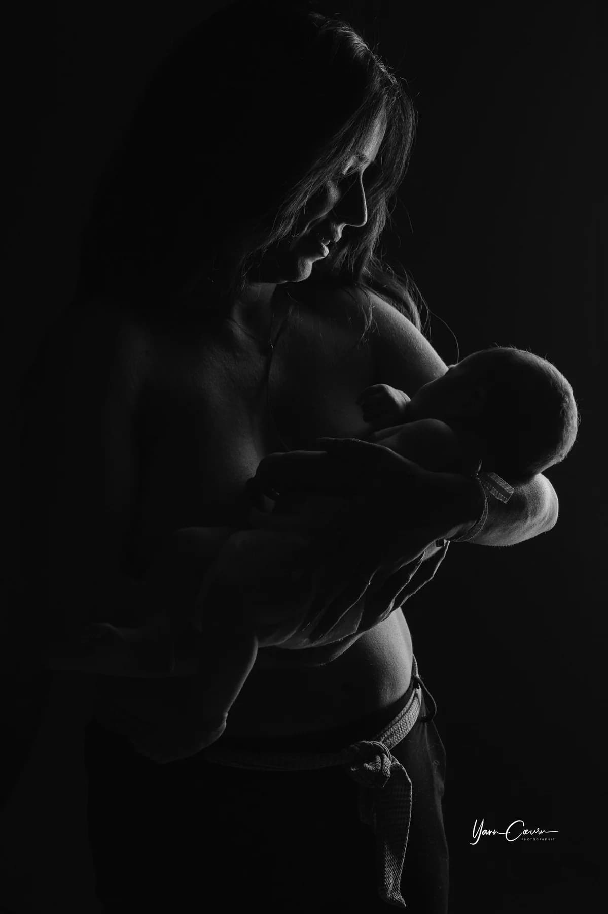 Portrait high-key noir et blanc de parents avec leur nouveau-né