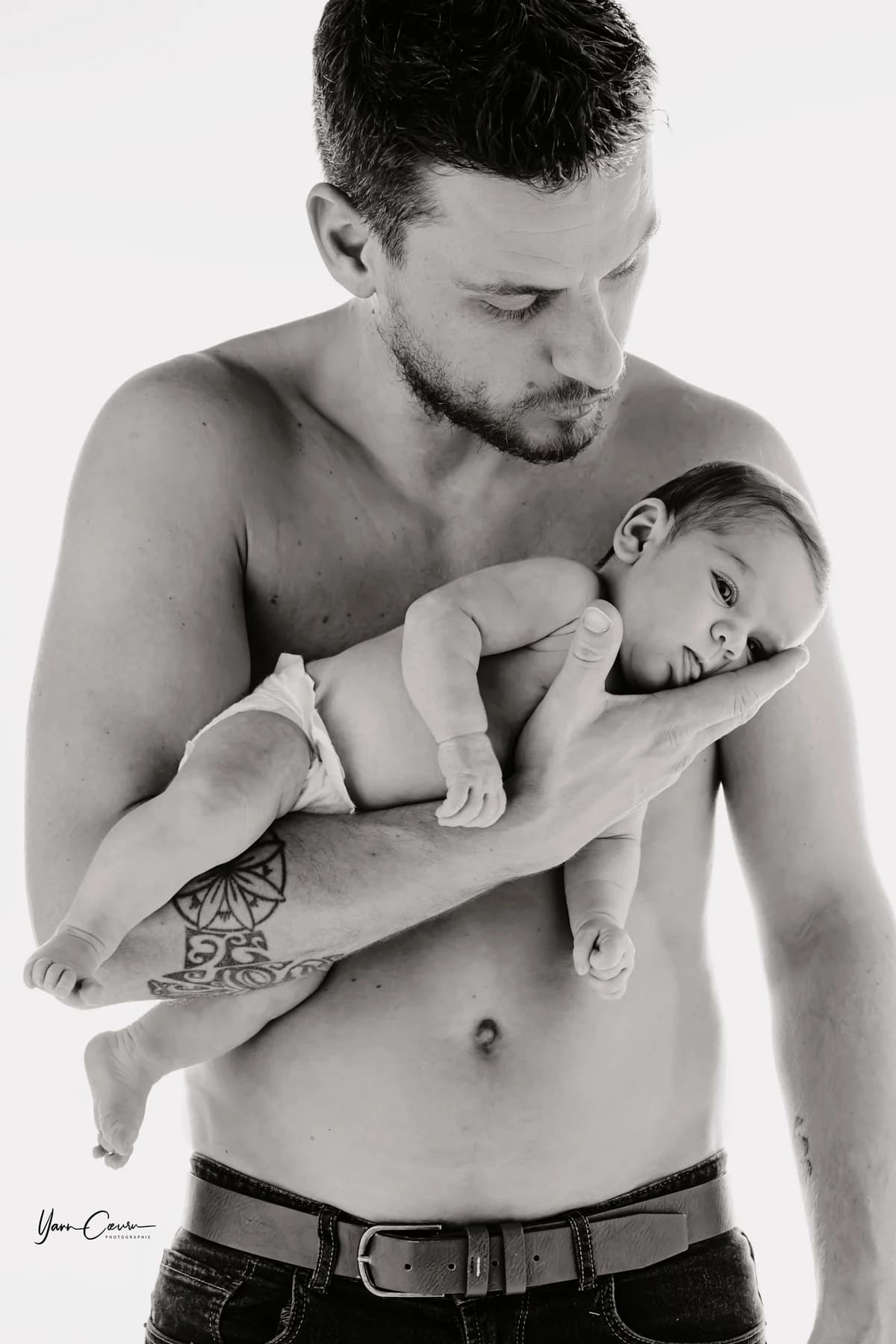 Papa embrassant son bébé avec tendresse en noir et blanc