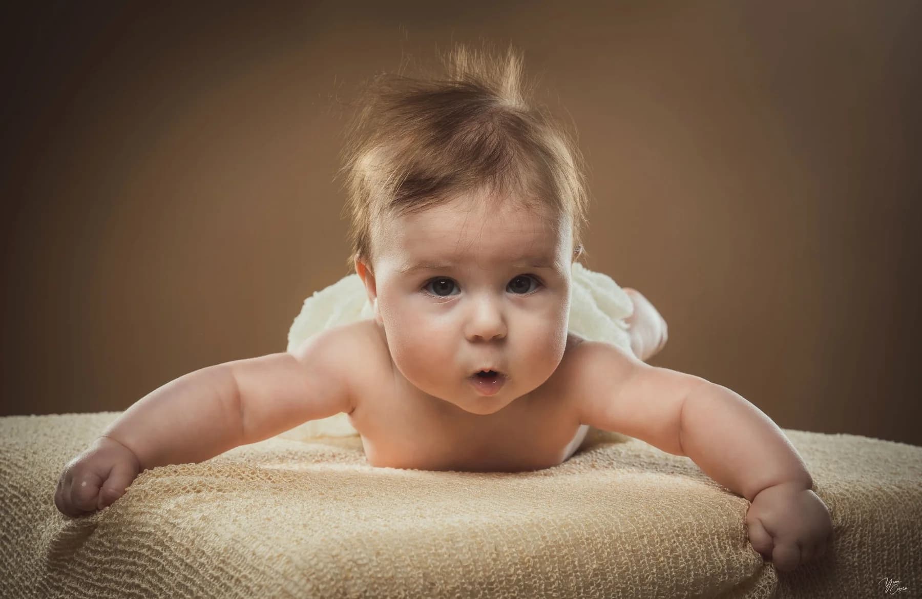Bébé en éveil sur un tissu doux lors d'une séance naissance en Ardèche