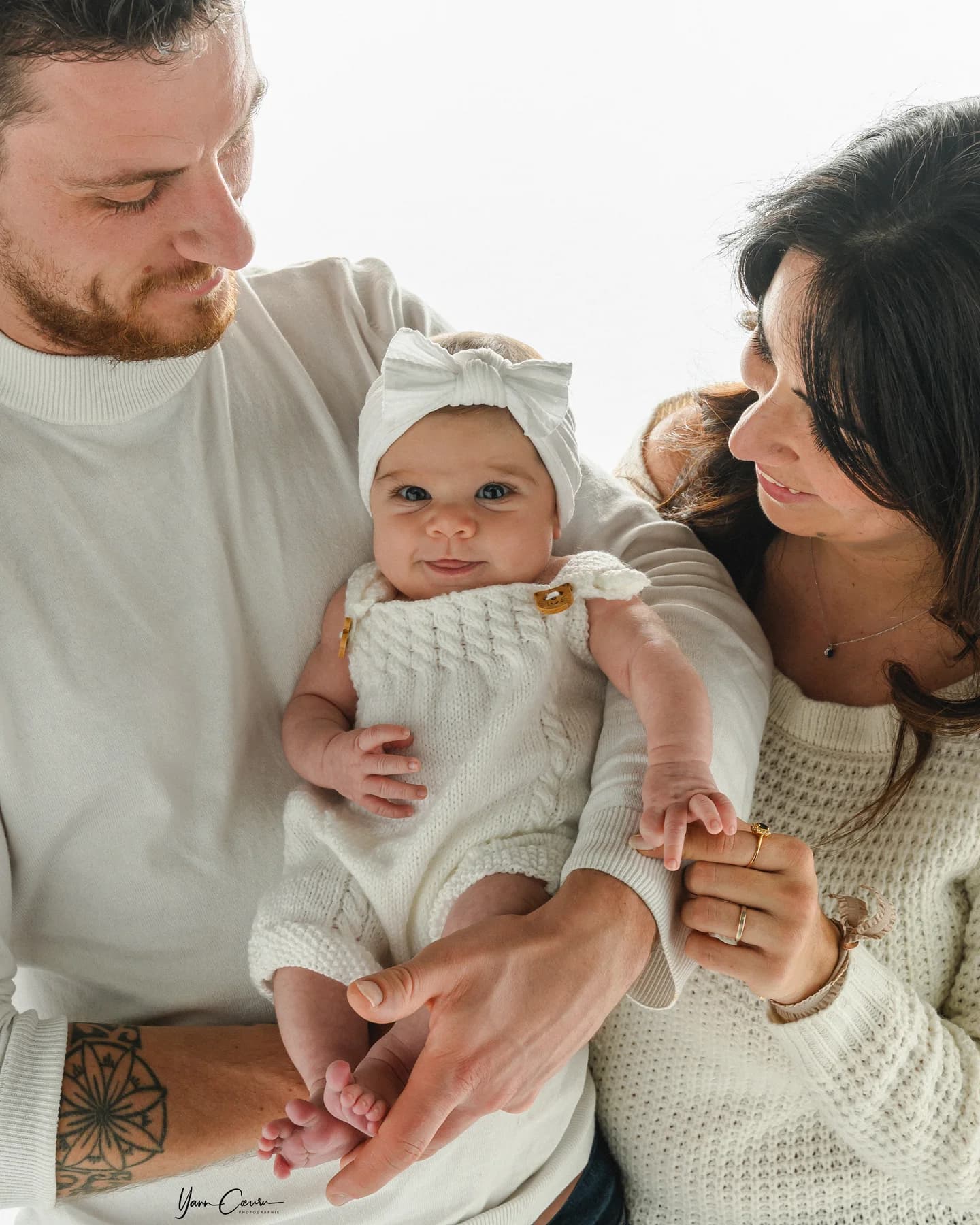 Séance naissance en famille avec bébé dans une ambiance lumineuse en studio