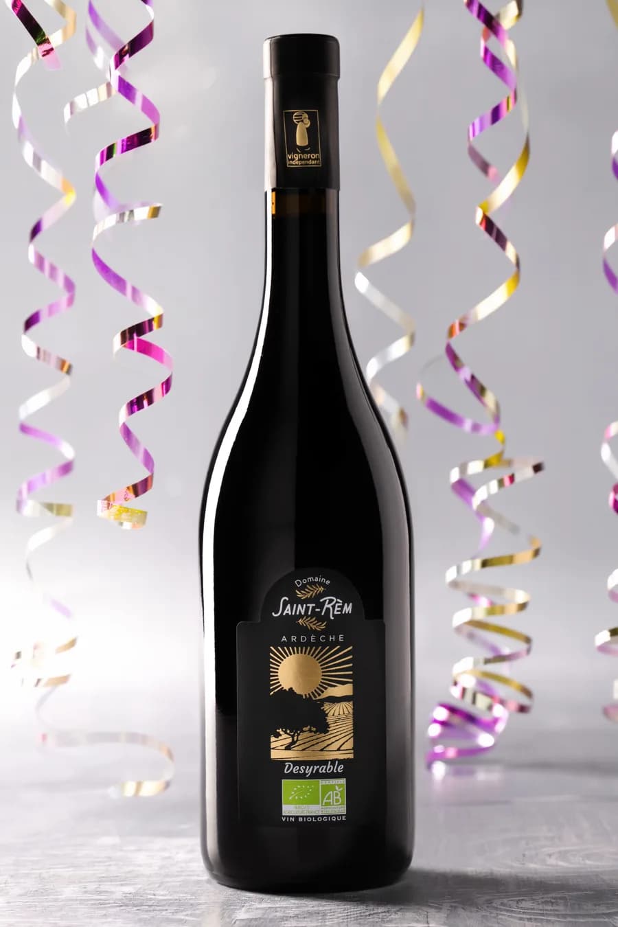 Bouteille de vin bio Desyrable du Domaine Saint-Rèm en ambiance festive, cotillons et couleurs vives