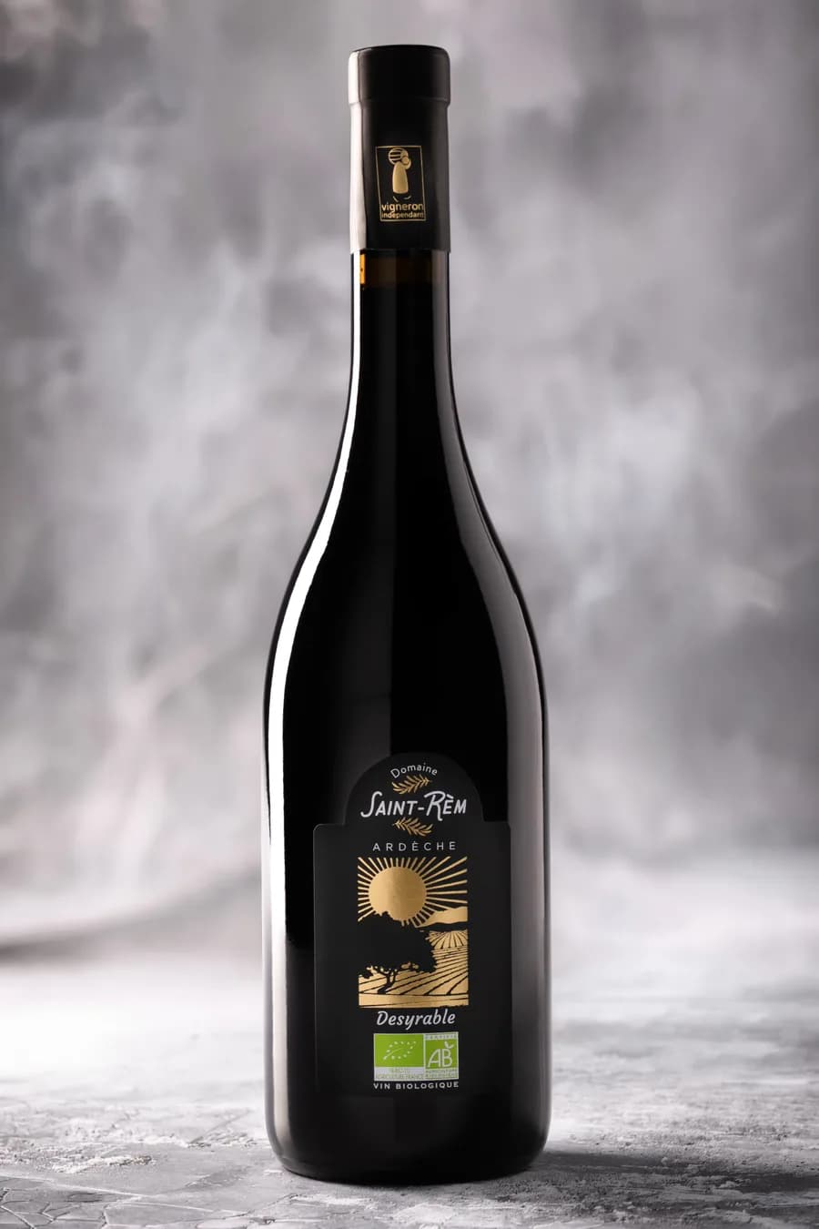Bouteille de vin bio Desyrable sur fond texturé gris, ambiance studio stylisée