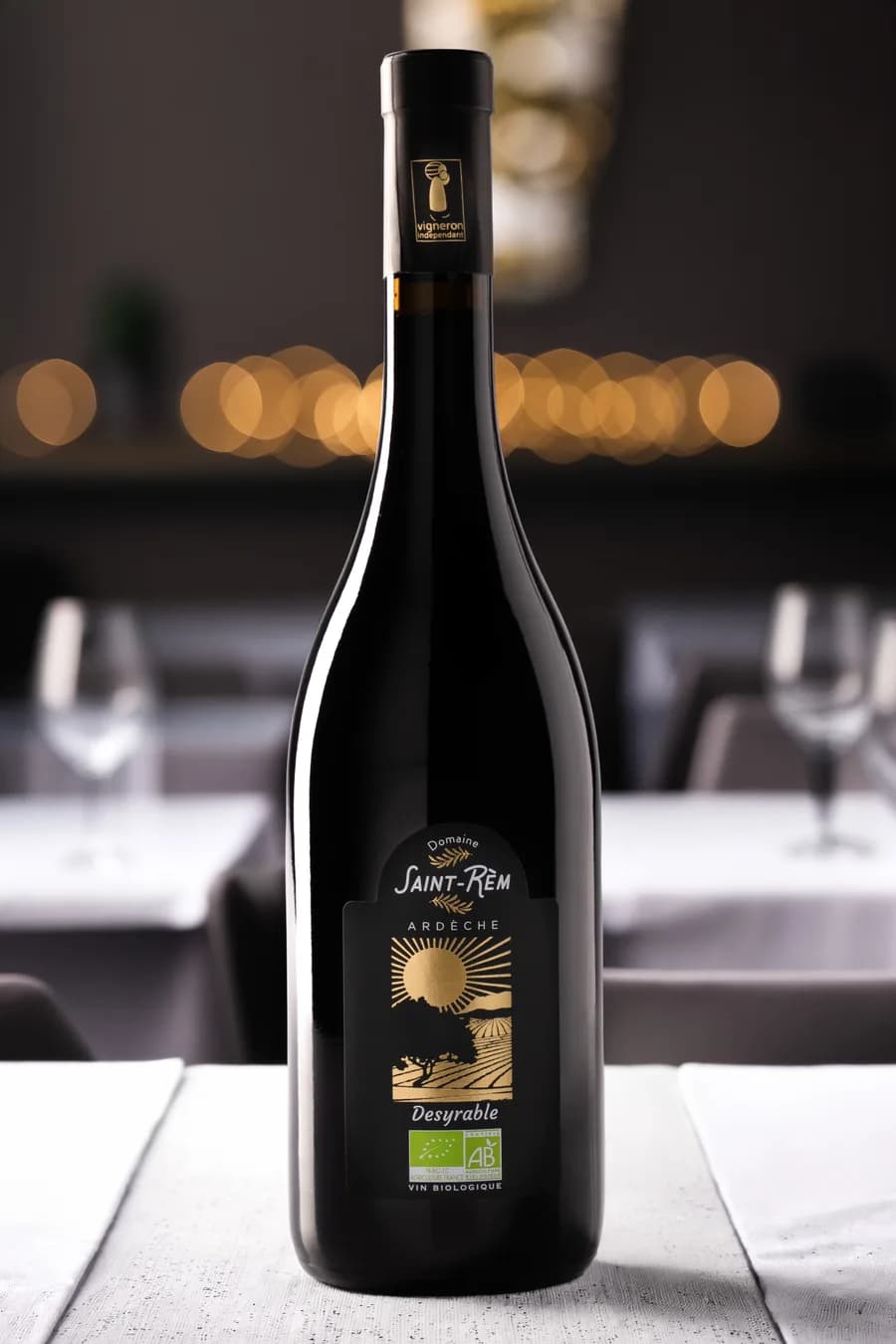 Bouteille de vin bio Desyrable en situation sur une table de restaurant, bokeh chaleureux