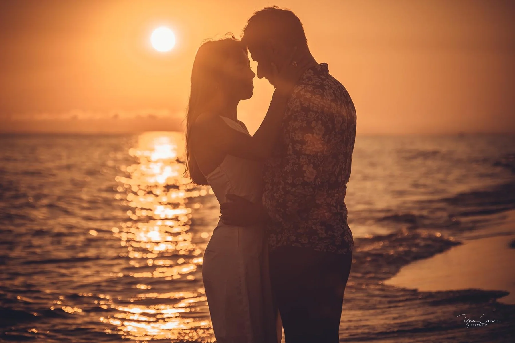 Couple échangeant un baiser en silhouette au coucher de soleil sur la plage de l'Espiguette