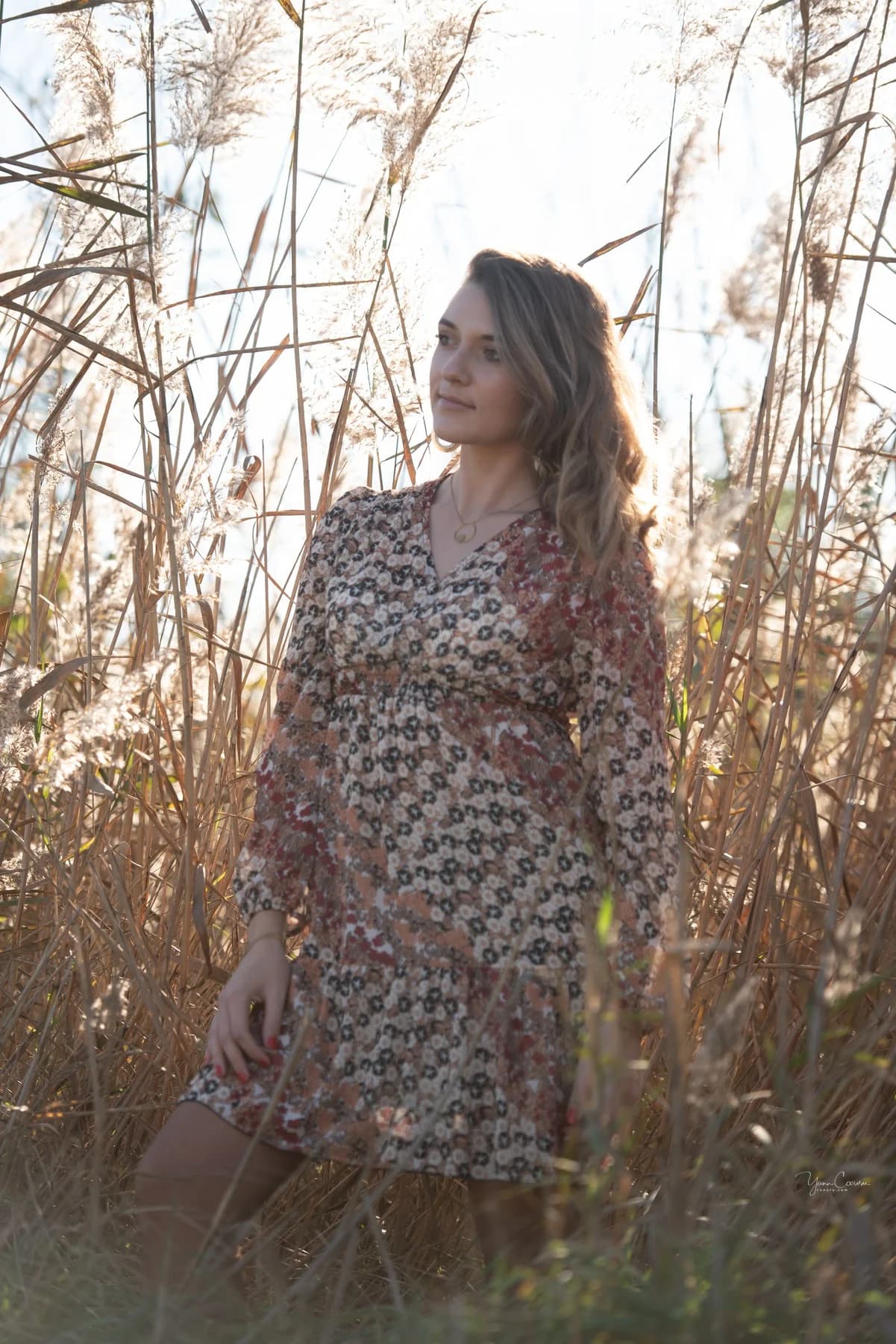 Femme en robe fleurie dans les roseaux dorés de l'étang de Méjean près de Palavas