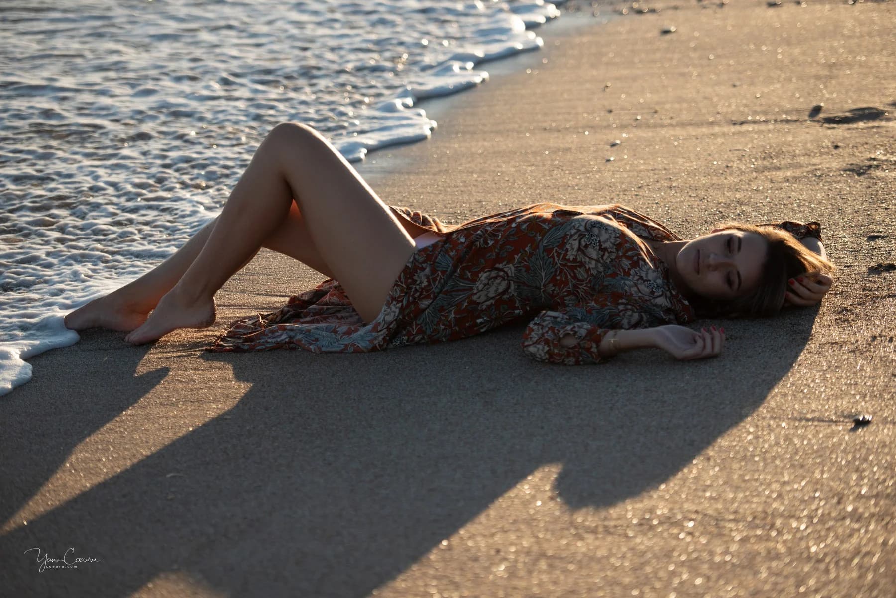 Femme allongée sur le sable mouillé près de l'écume à Palavas