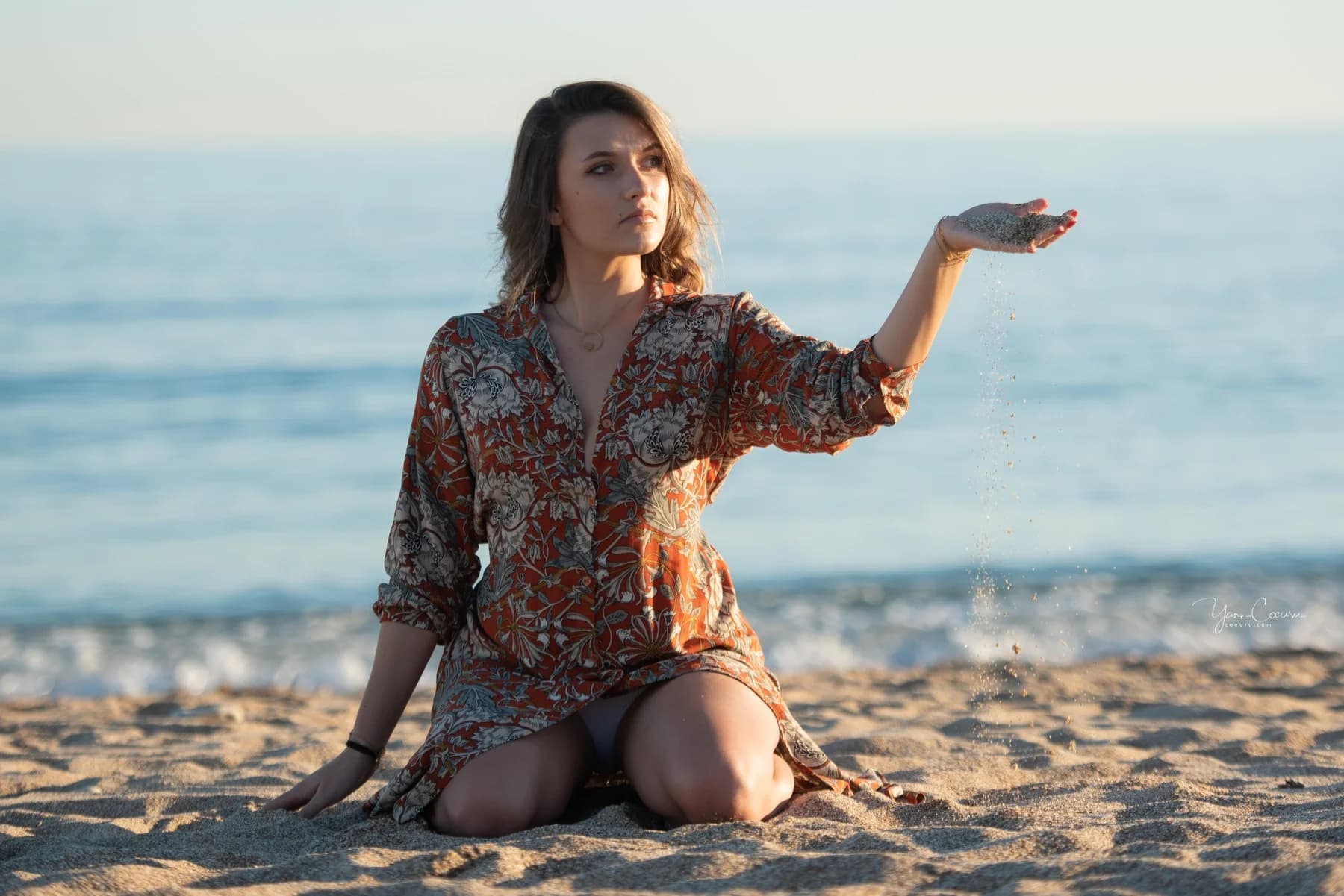 Femme assise sur le sable de Palavas, robe bohème, sable qui coule entre ses doigts