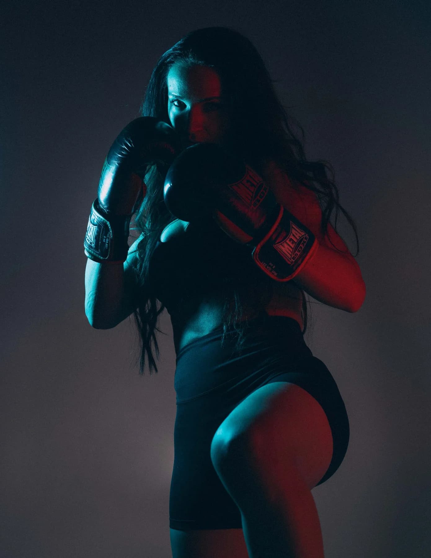 Portrait sportif boxe féminine éclairage créatif rouge et cyan en studio