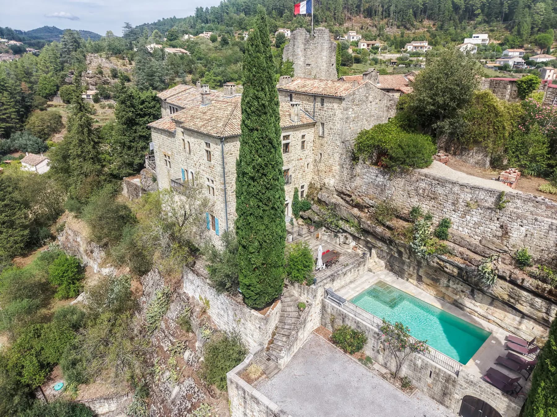 Vue aérienne par drone d'un château à Ucel, piscine et vallée de l'Ardèche — photographe immobilier Aubenas