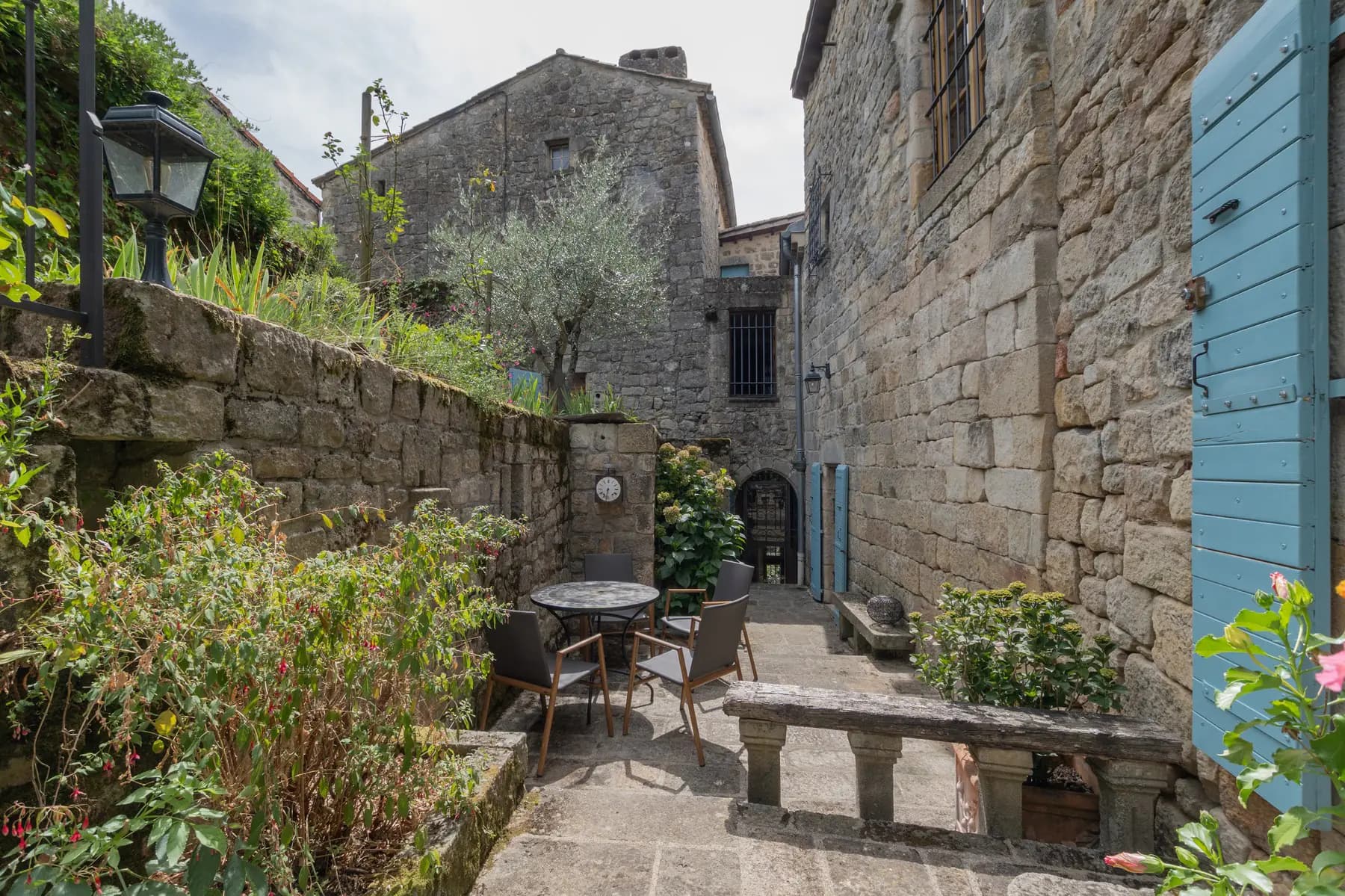 Cour aux oliviers et volets bleus d'un château à Ucel — photographe immobilier Aubenas