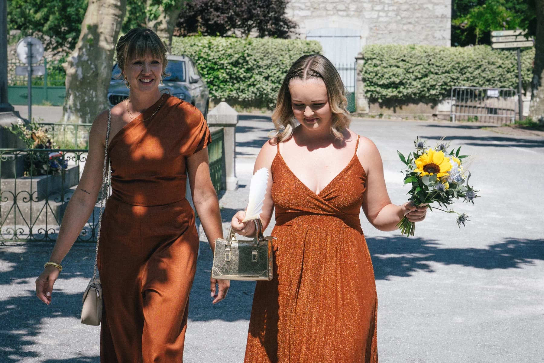 Mariage Sud Ardèche : invitées en robes terracotta arrivant à la mairie.
