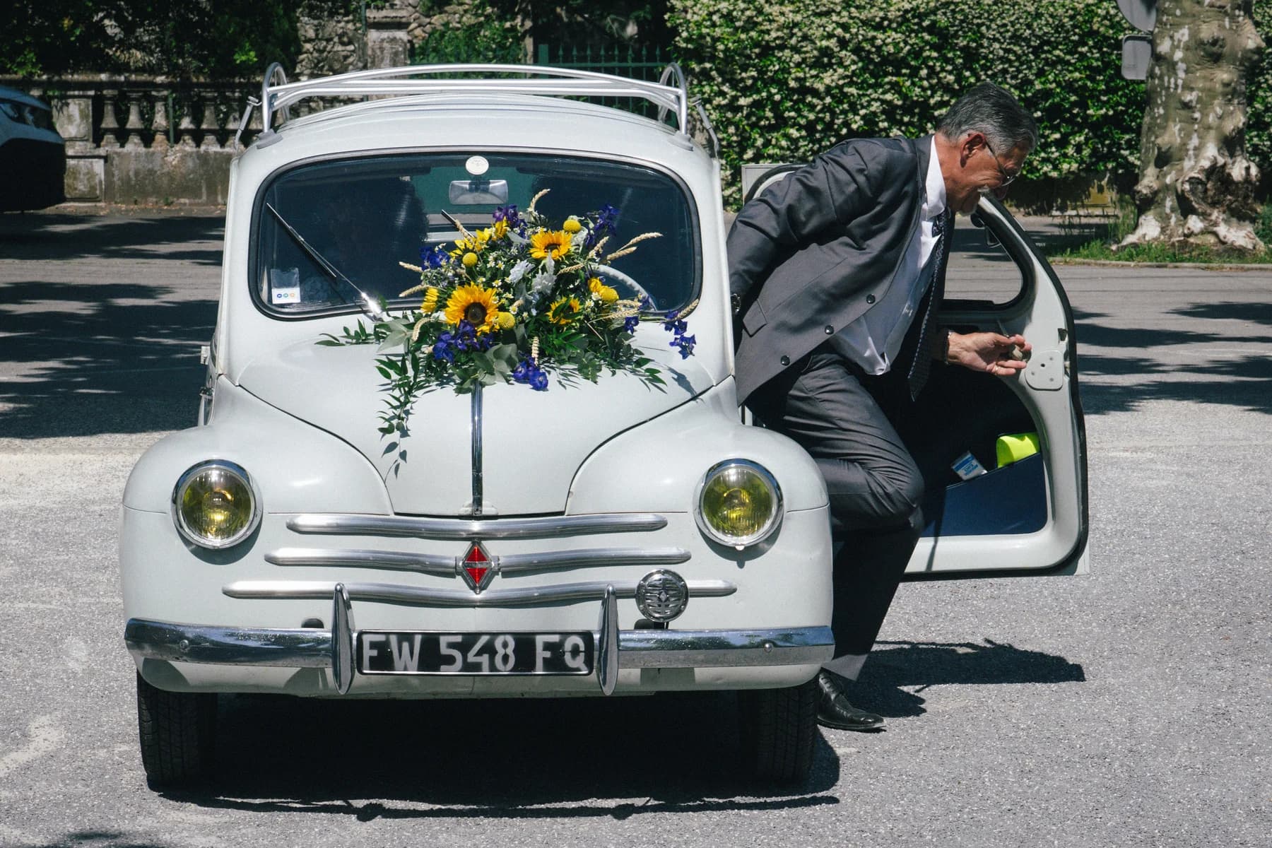 Mariage en Ardèche : arrivée de la mariée en 4CV fleurie devant la mairie de Saint-Alban-Auriolles.