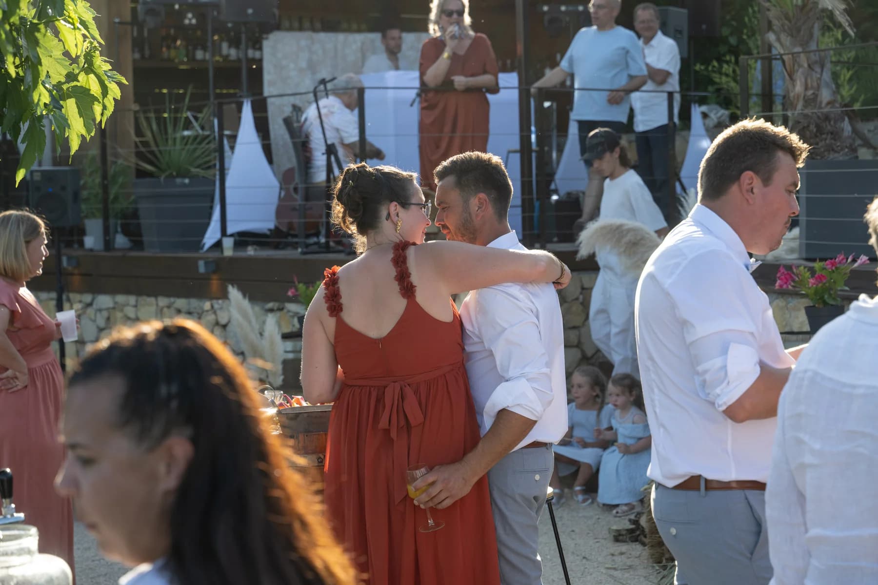 Mariage champêtre en Ardèche : invités rassemblés autour des fûts pendant le vin d'honneur.