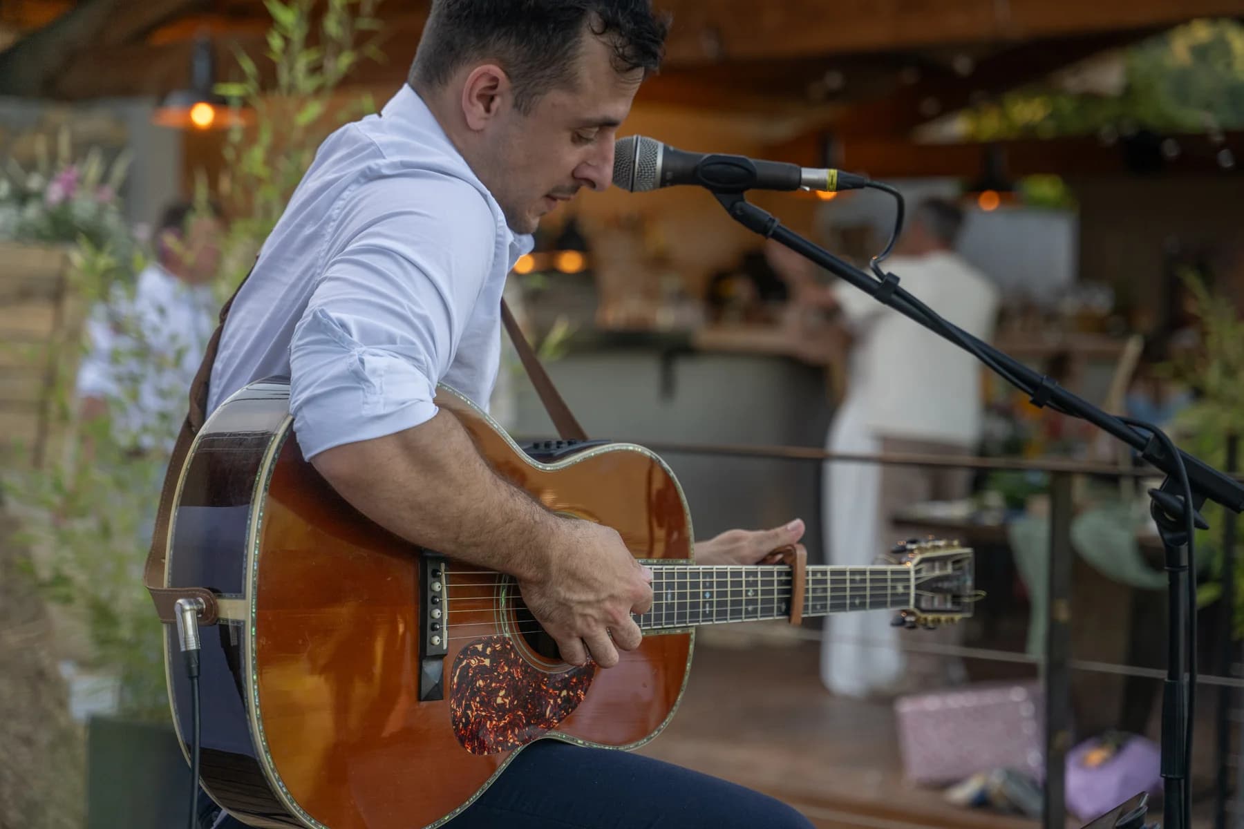 Mariage champêtre à Ruoms : guitariste en concert pendant la soirée à la ferme.