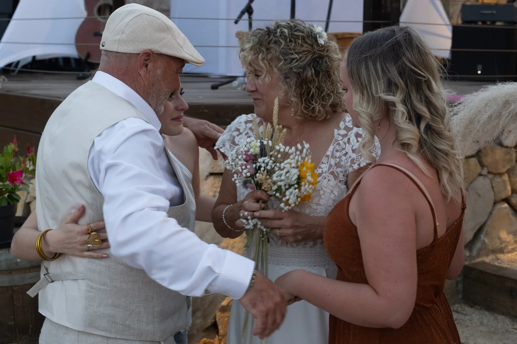 Mariage champêtre à Ruoms : embrassade des mariés avec leurs proches après les discours.