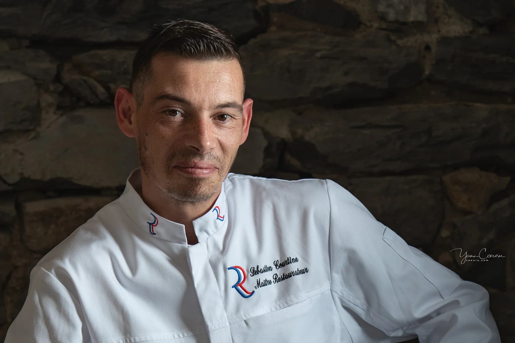 Portrait professionnel d'un maître restaurateur en veste blanche, réalisé sur son lieu de travail en Ardèche.