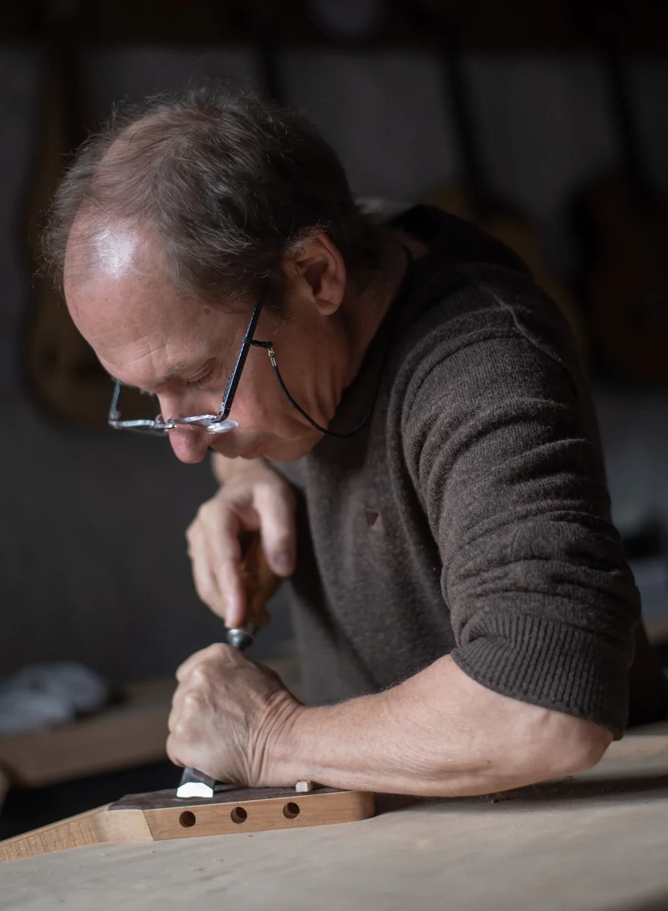 Artisan luthier concentré au travail dans son atelier, Entreprise à Saint Genest de Bauzon en Ardèche.