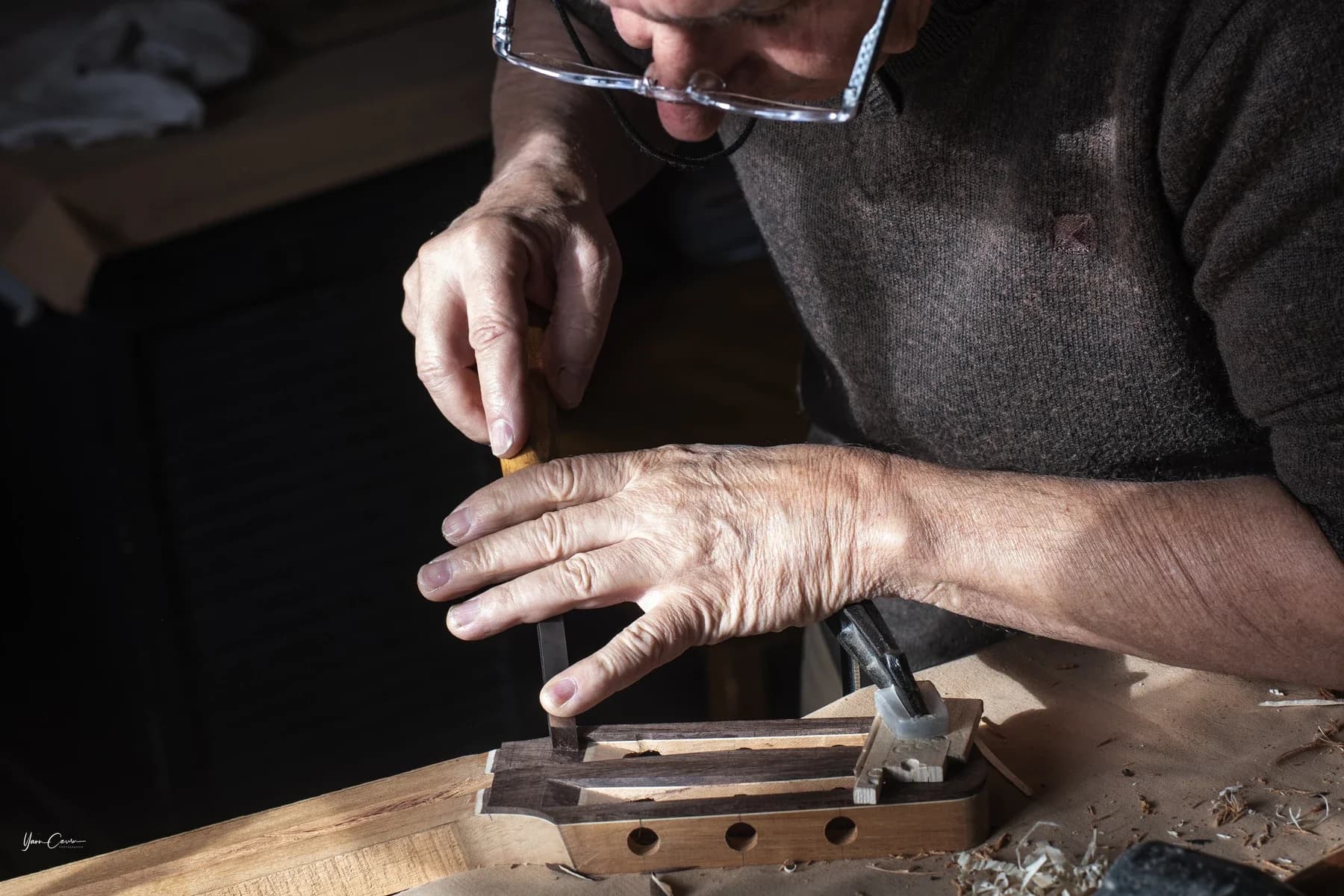 Artisan luthier travaillant le bois à l'établi, reportage Entreprise à Saint Genest de Bauzon en Ardèche.