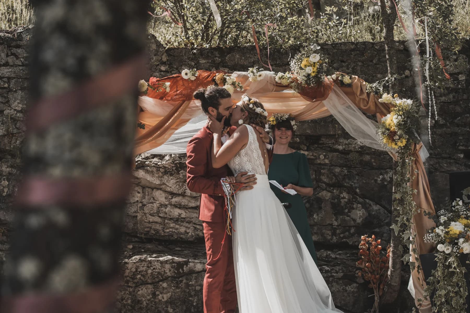 Le baiser des mariés sous l’arche de la cérémonie — Domaine de Bagard, Sauve (Gard)