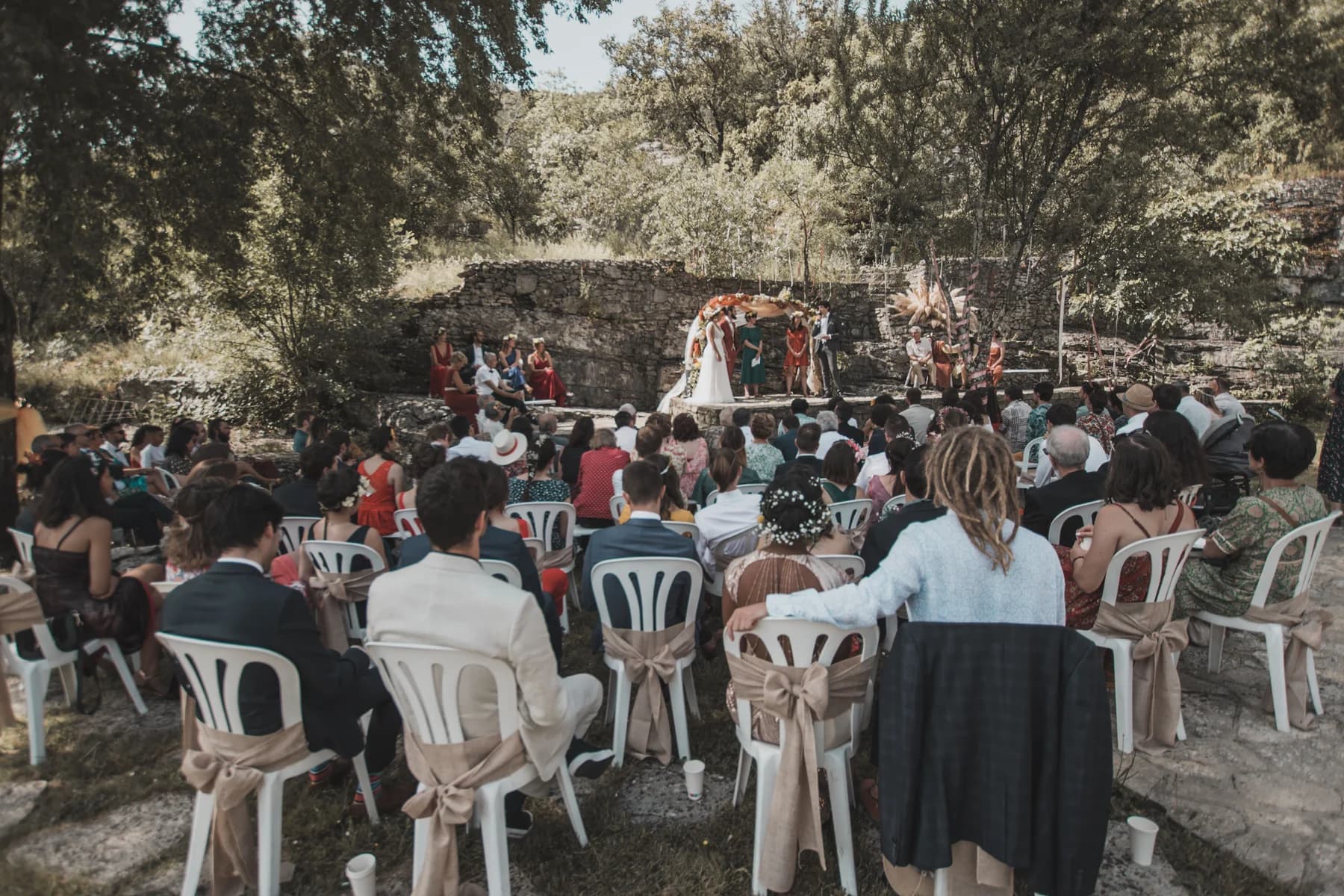 Cérémonie laïque en plein air devant les invités sur la terrasse de pierre — Domaine de Bagard, Sauve