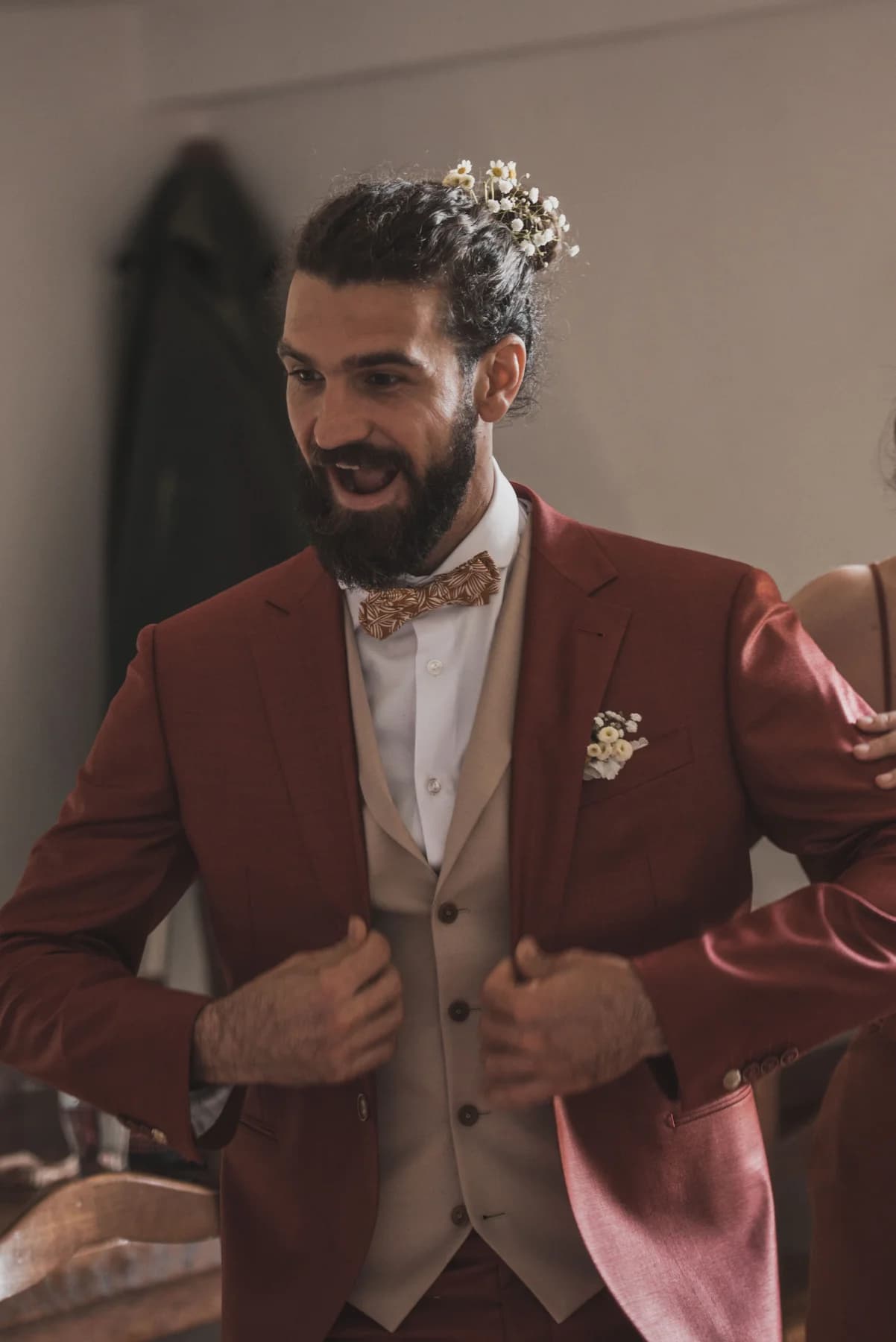 Le marié boutonne sa veste terracotta — mariage au Domaine de Bagard, Sauve (Gard)