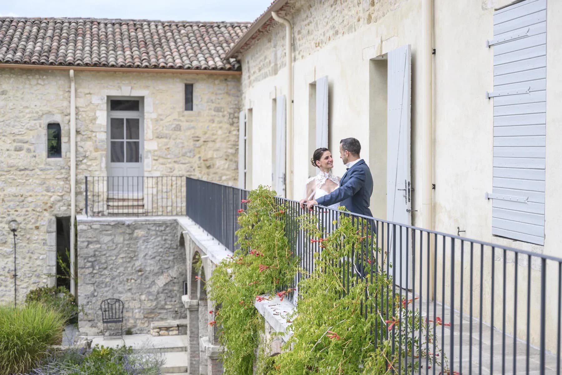 Couple enlacé sur une terrasse en pierre lors d'un mariage au Domaine de la Bedosse, à Alès, architecture traditionnelle
