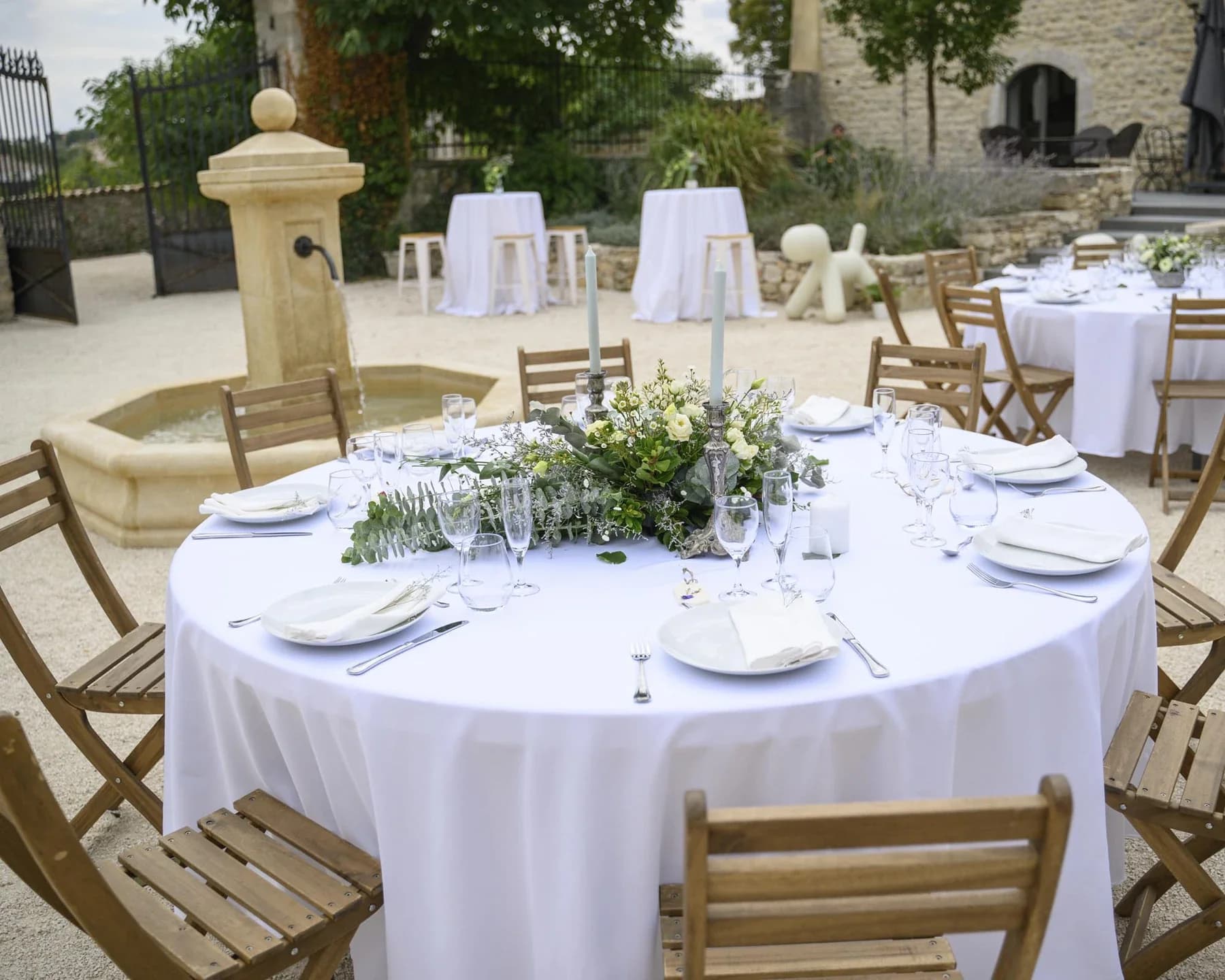 Table ronde mariage au Domaine de la Bedosse, à Alès dressée en extérieur avec nappe blanche, fleurs et bougies