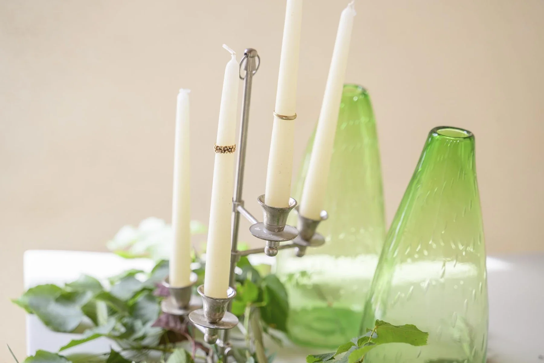 Mariage au Domaine de la Bedosse, à Alès : candélabres argentés avec bougies blanches et verre vert clair, décoration florale élégante