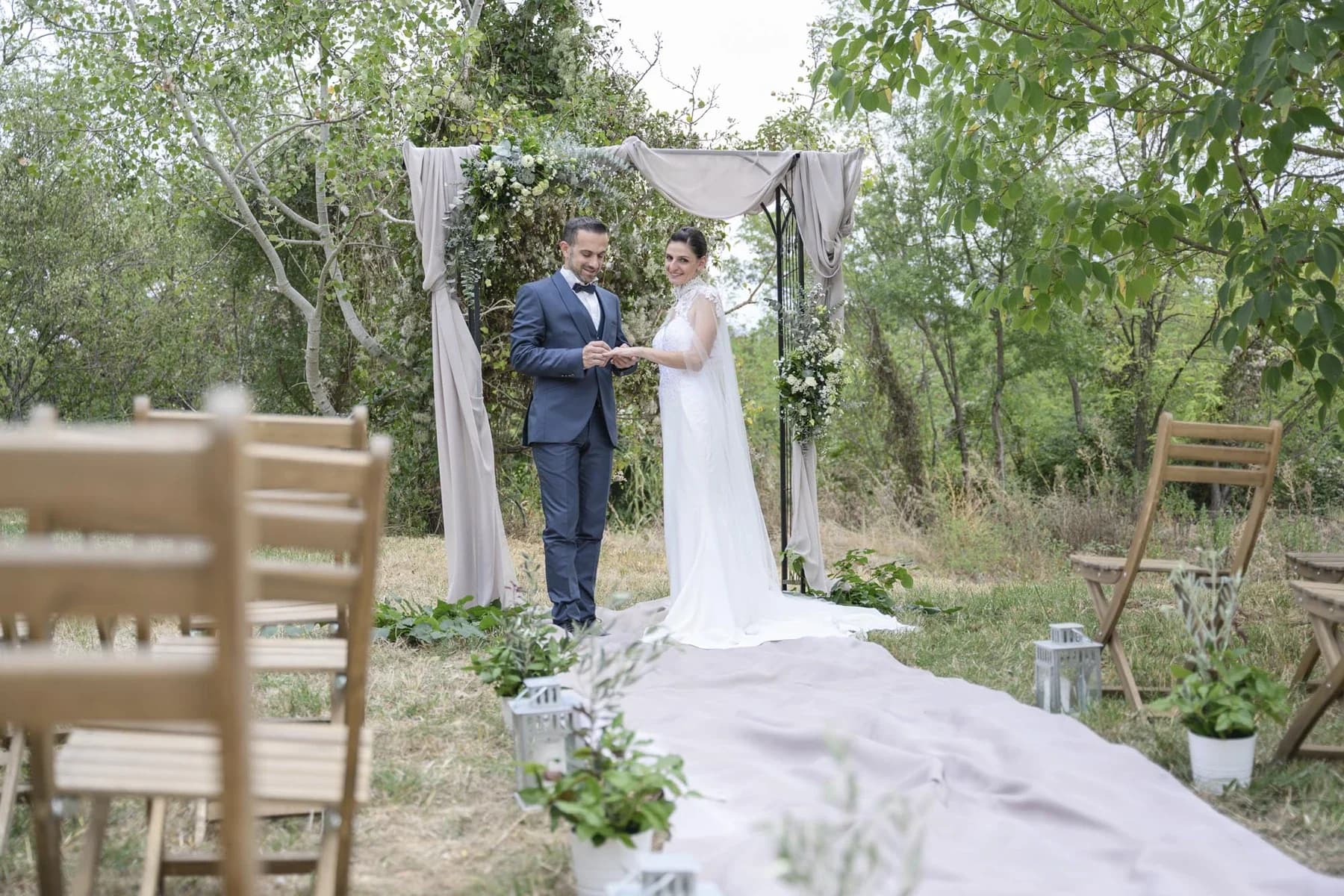 Photographe mariage Gard — séance inspiration au Domaine de la Bedosse à Alès, échange des alliances sous une arche fleurie