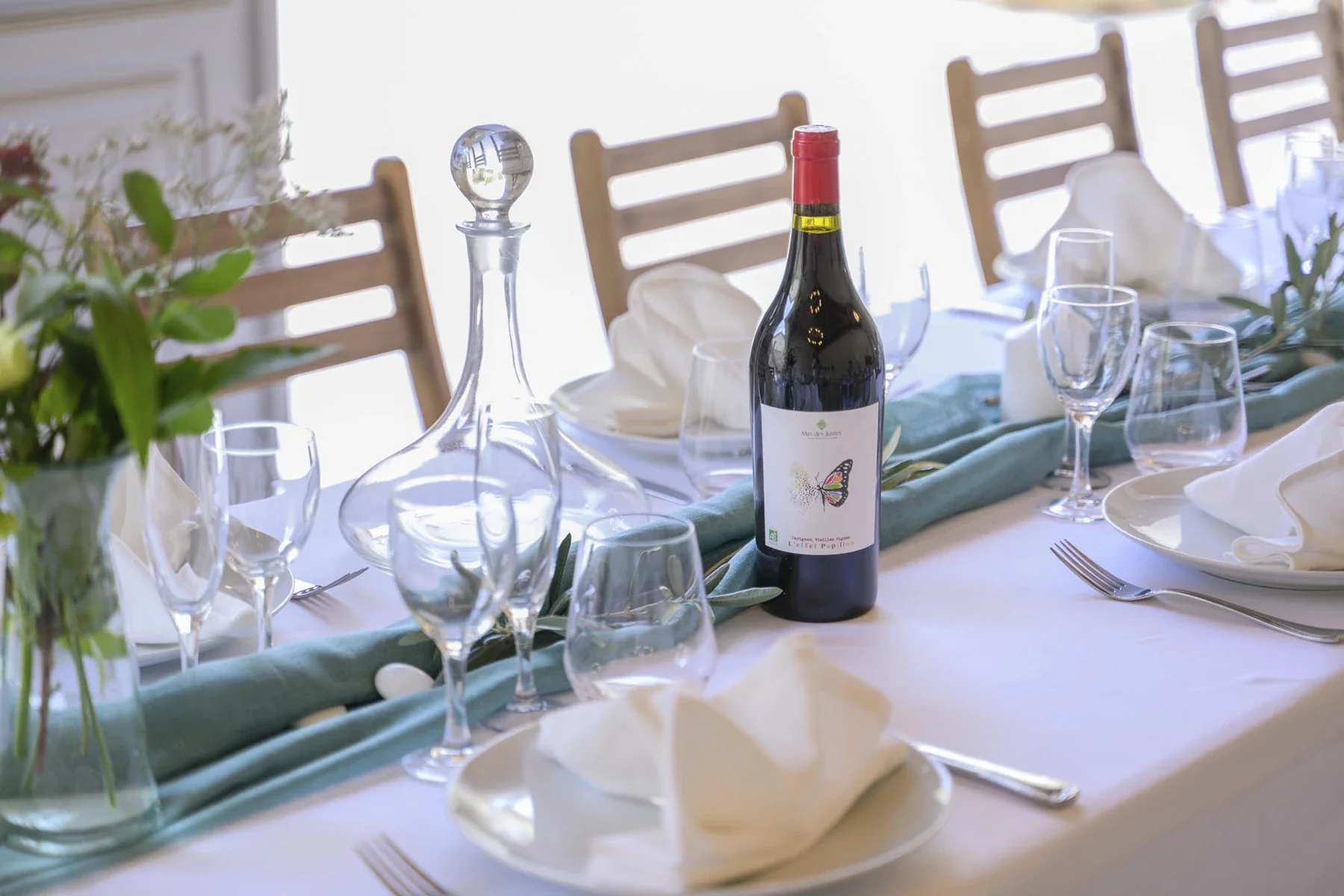 Élégante table de mariage en Ardèche avec décoration florale, verres et vin rouge