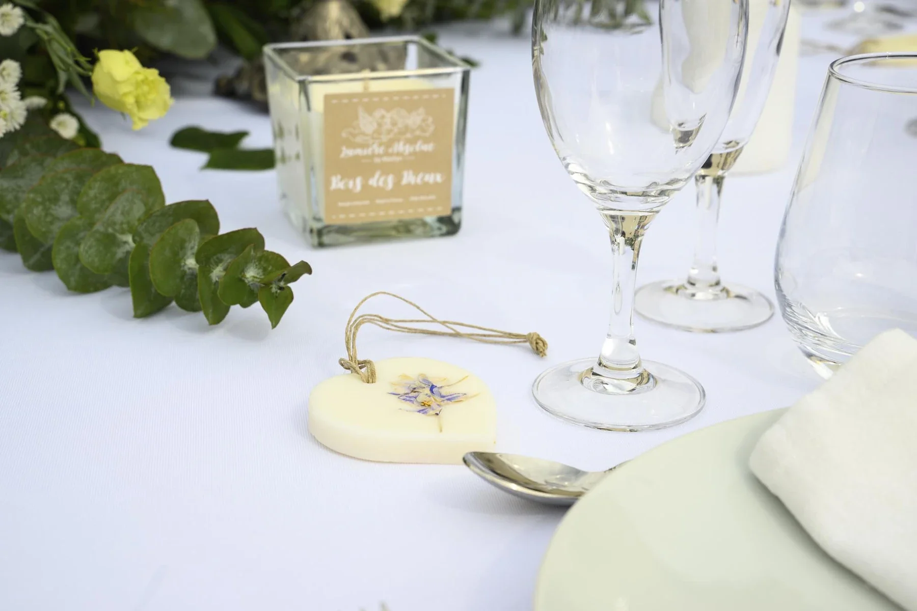 Décoration de table mariage en Ardèche avec fleurs jaunes, verres et marque-place artisanal