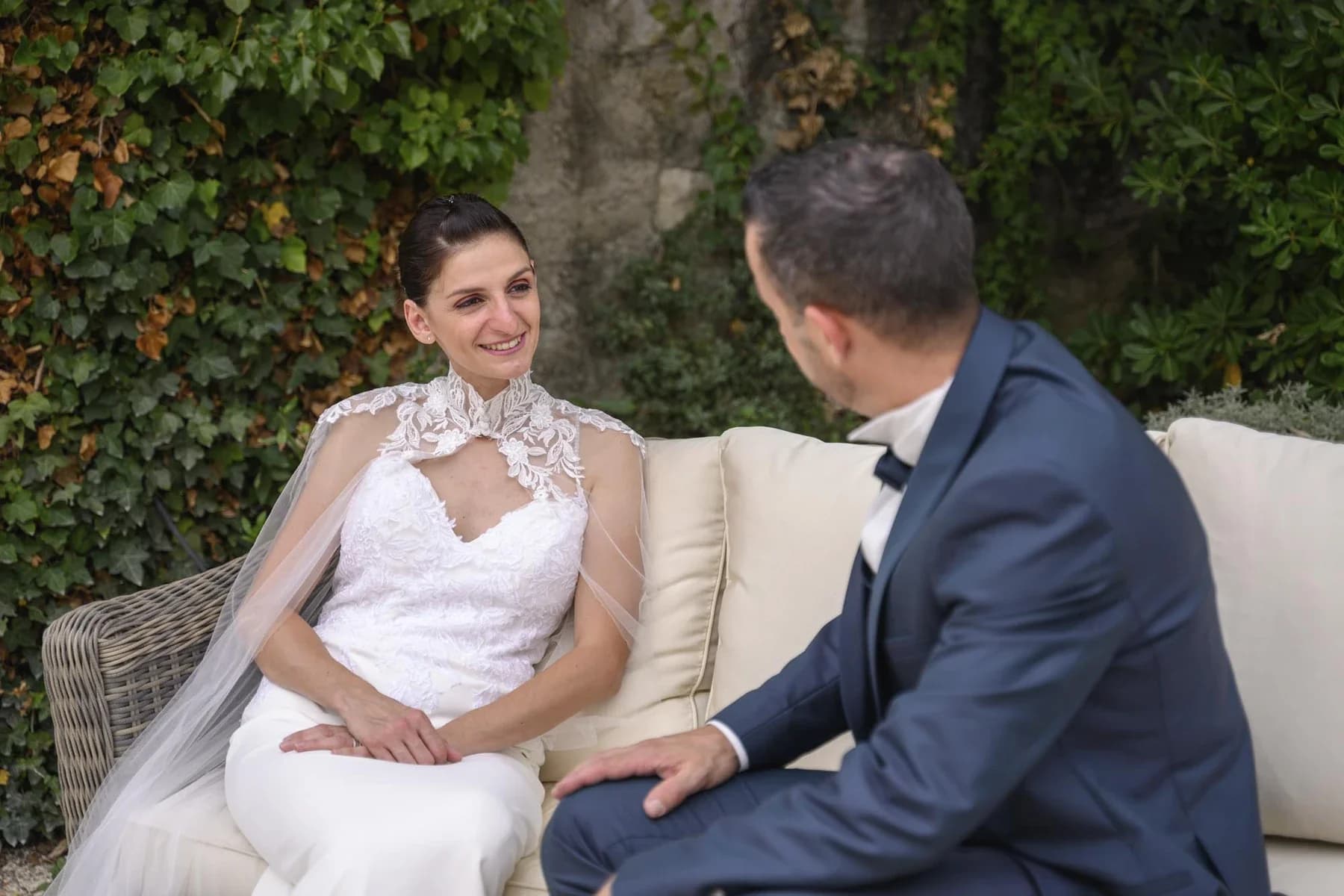 Couple marié souriant en tenue de cérémonie dans un jardin verdoyant au Domaine de la Bedosse, à Alès
