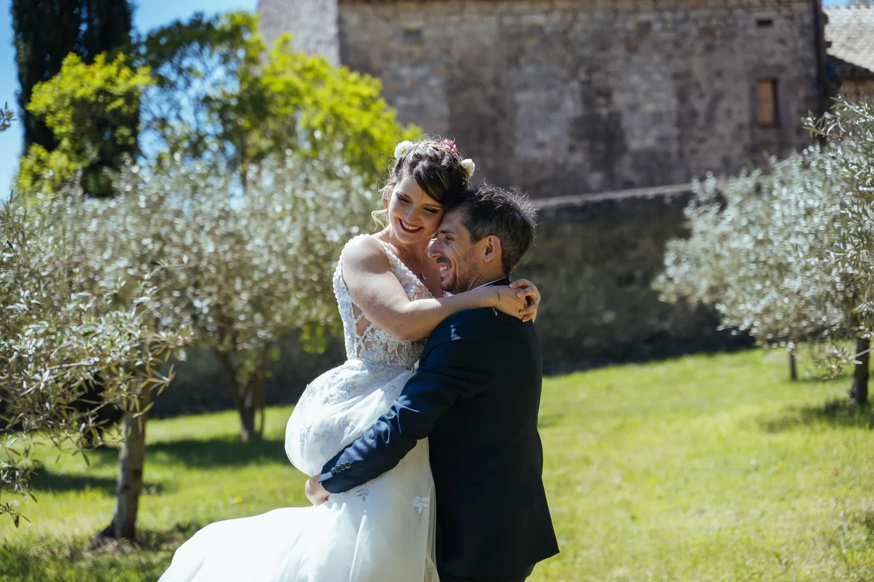 Photographe mariage Ardèche — marié soulevant la mariée en robe blanche dans une oliveraie