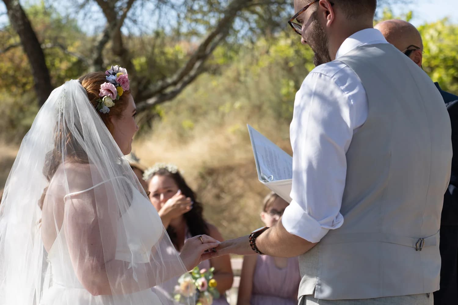 Mariages en plein air, échange d'alliances émouvant entre mariés lors d'une cérémonie champêtre ensoleillée.