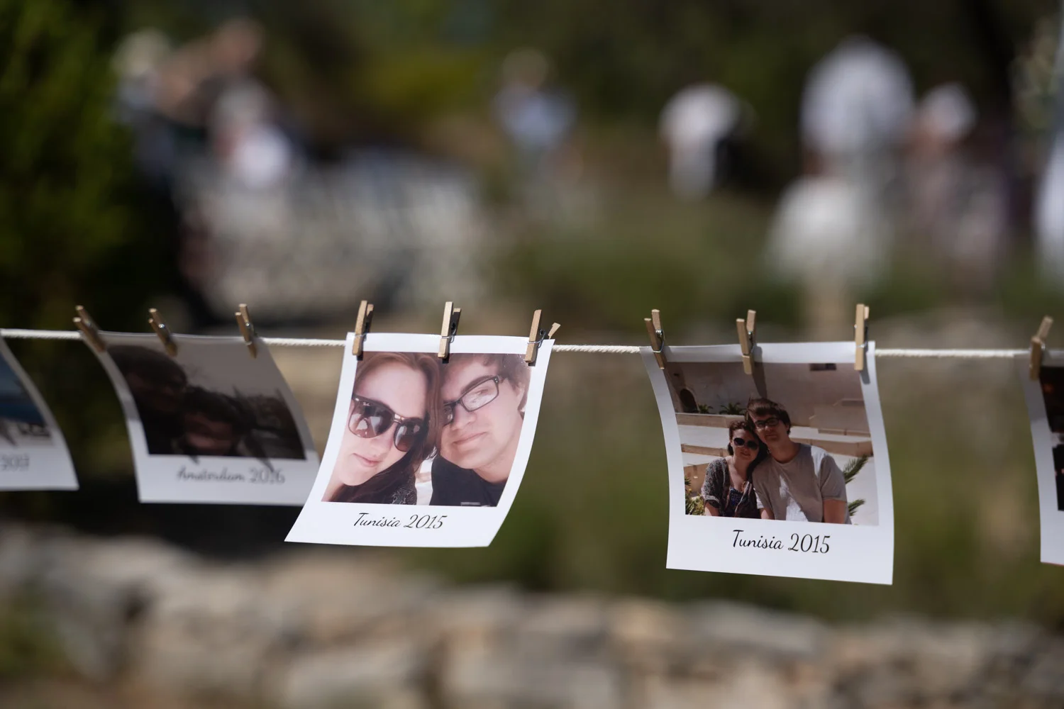 Mariages : polaroids de couple accrochés sur une corde avec des pinces en bois, ambiance souvenir et tendresse.