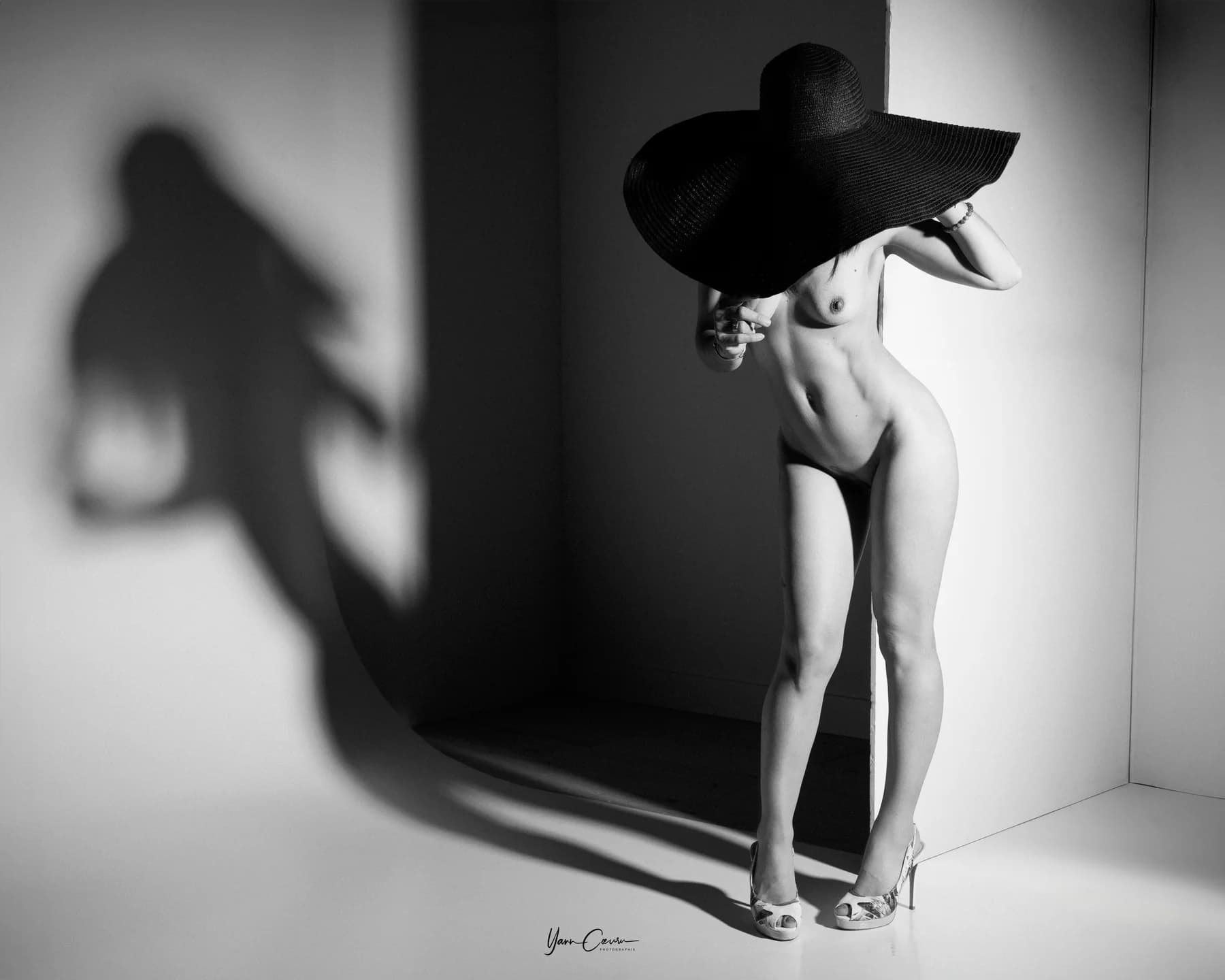 Nu artistique Gard, femme au grand chapeau noir en studio, ambiance Hérault Montpellier plage, noir et blanc élégant.