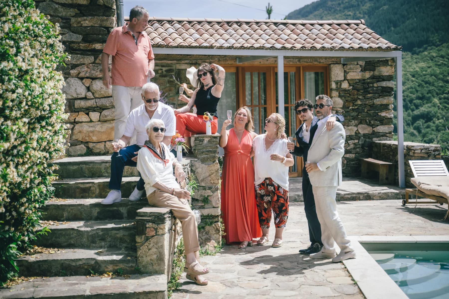La famille réunie sur les marches de pierre du mas — séance de fiançailles à Saint-Mélany (Ardèche)
